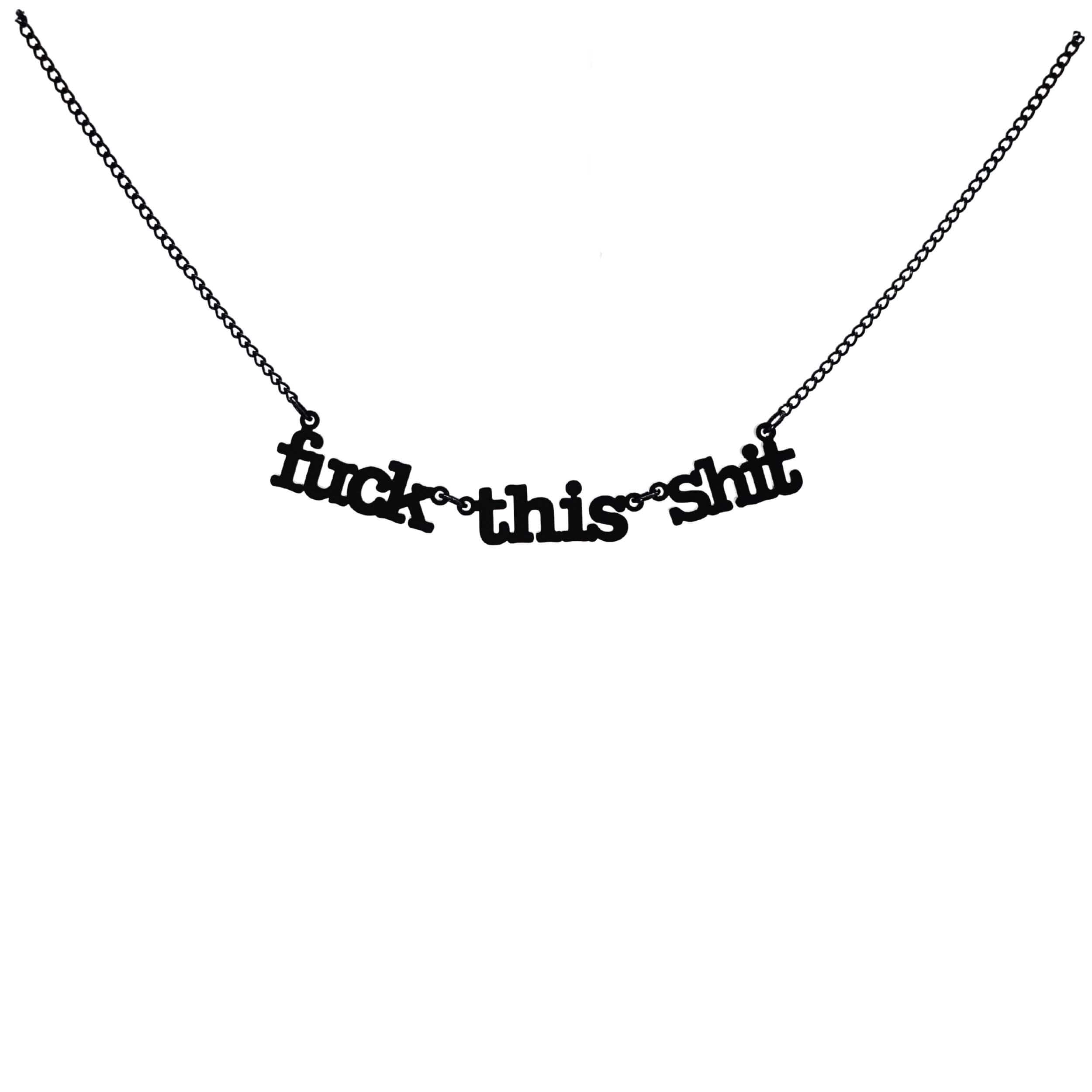 F*ck this sh*t necklace in matte black shown hanging against a white backround. 