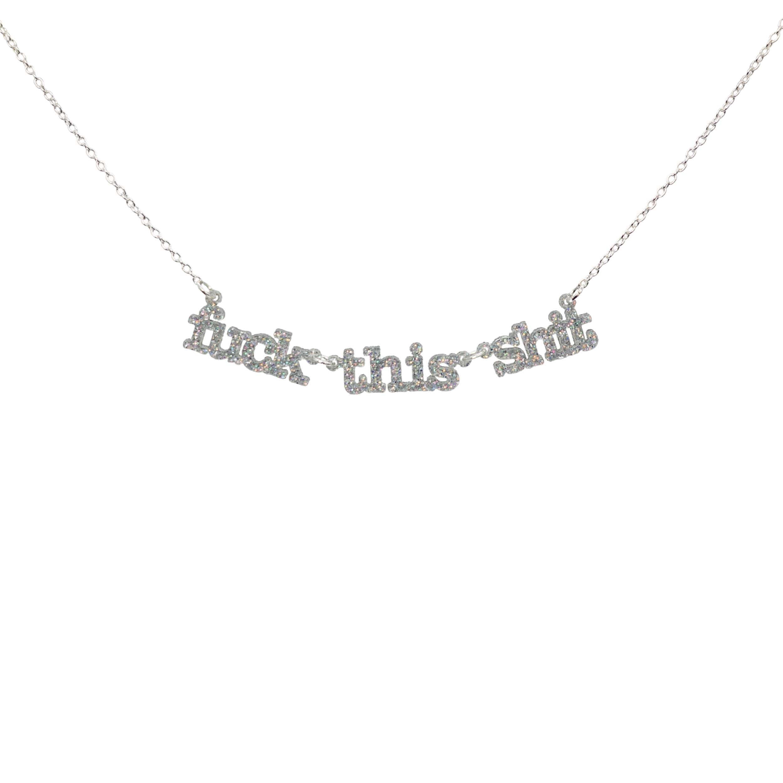F*ck this sh*t necklace in silver glitter shown hanging against a white backround. 