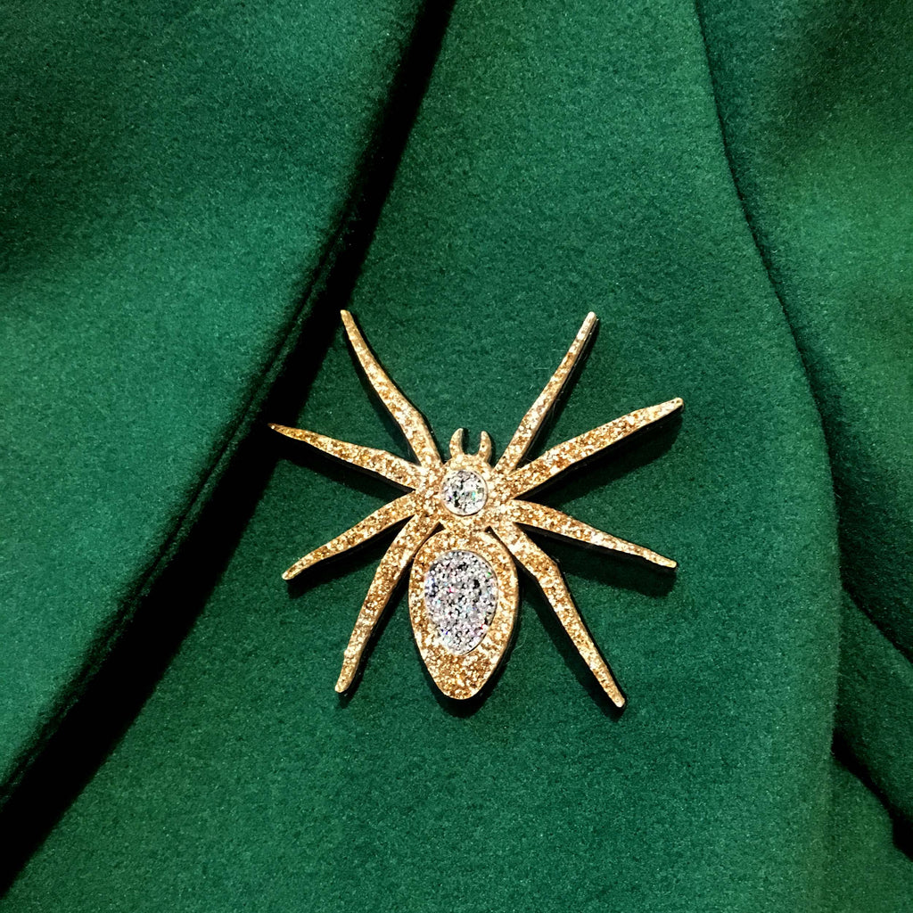 Gold Lady Hale Spider brooch shown on a green coat. 