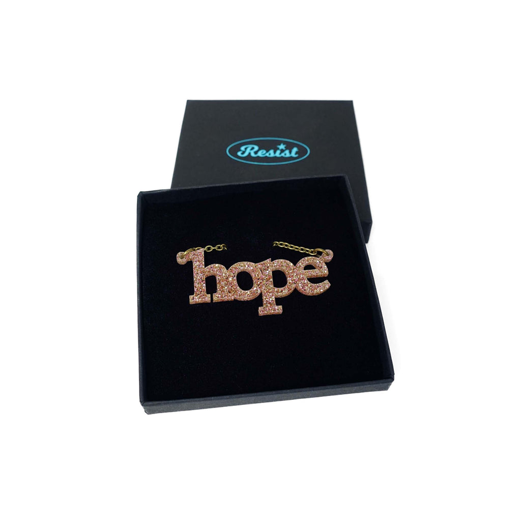Hope necklace in pink fizz glitter shown in a Wear and Resist gift box. 