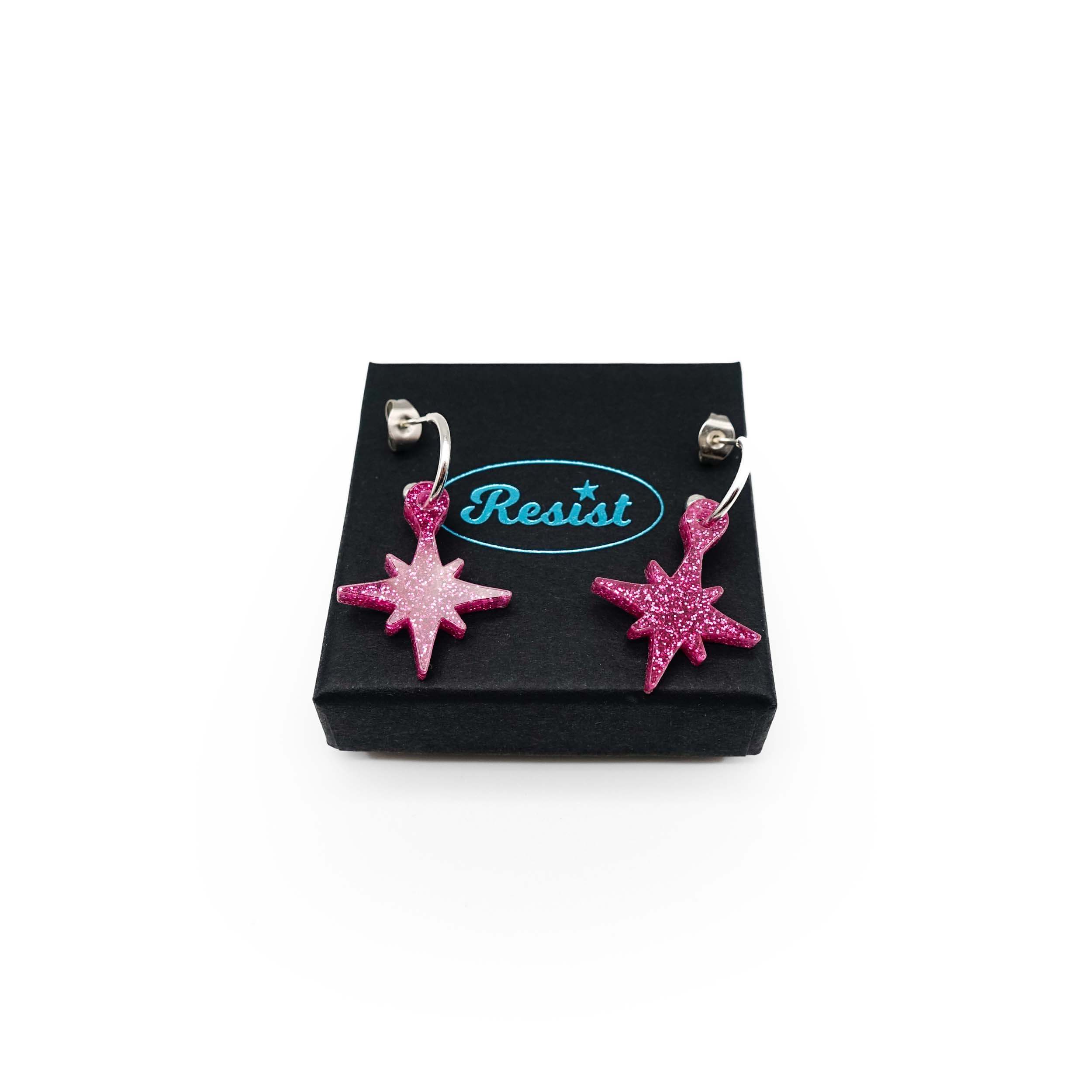 Hot pink glitter limited edition Festive Vintage Star earrings, shown on a Wear and Resist gift box.  