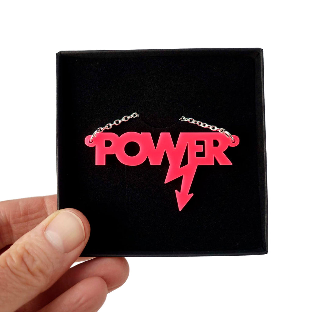 Mini power necklace in hot pink shown in a Wear and Resist gift box. 
