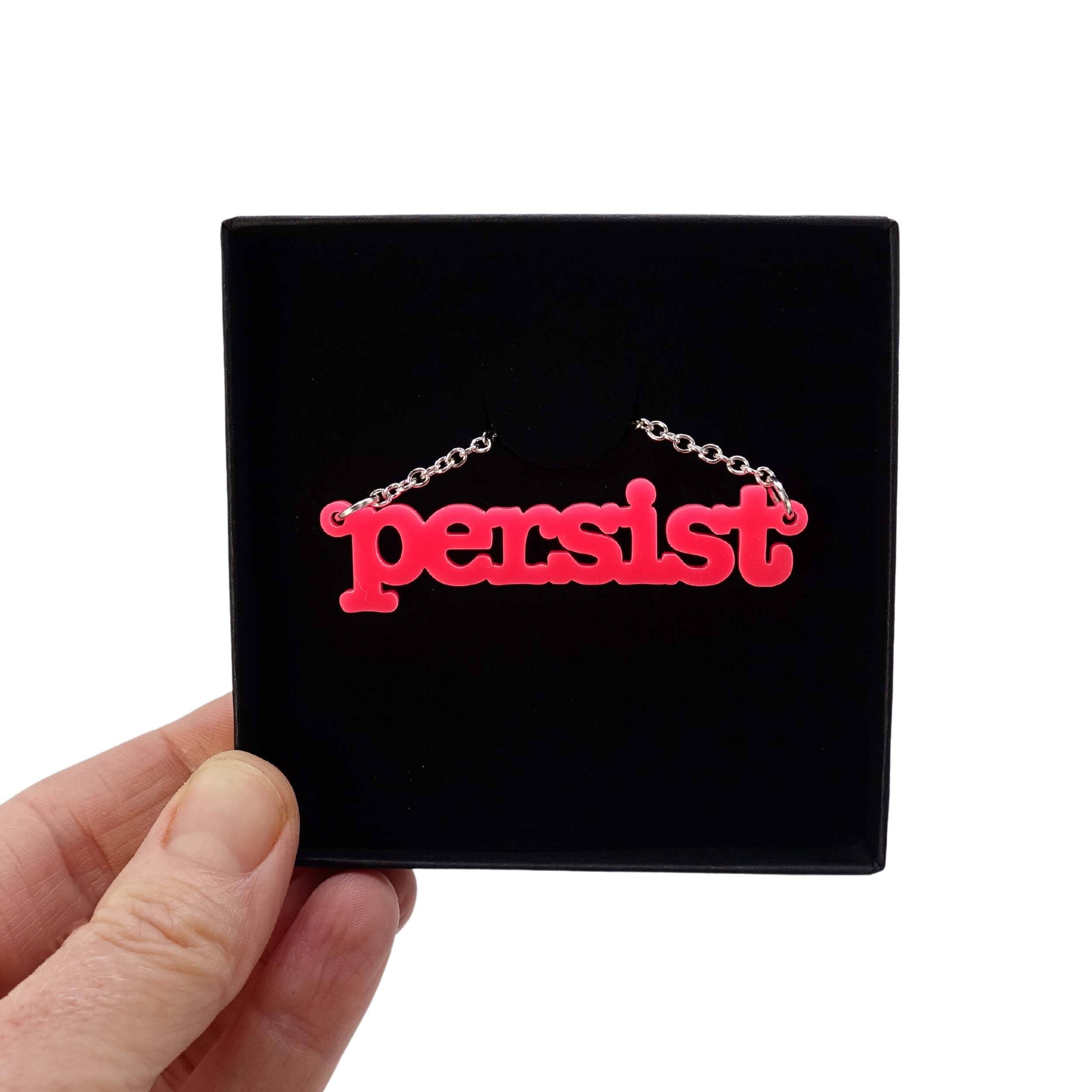 Hot pink Persist necklace shown in a Wear and Resist gift box. 