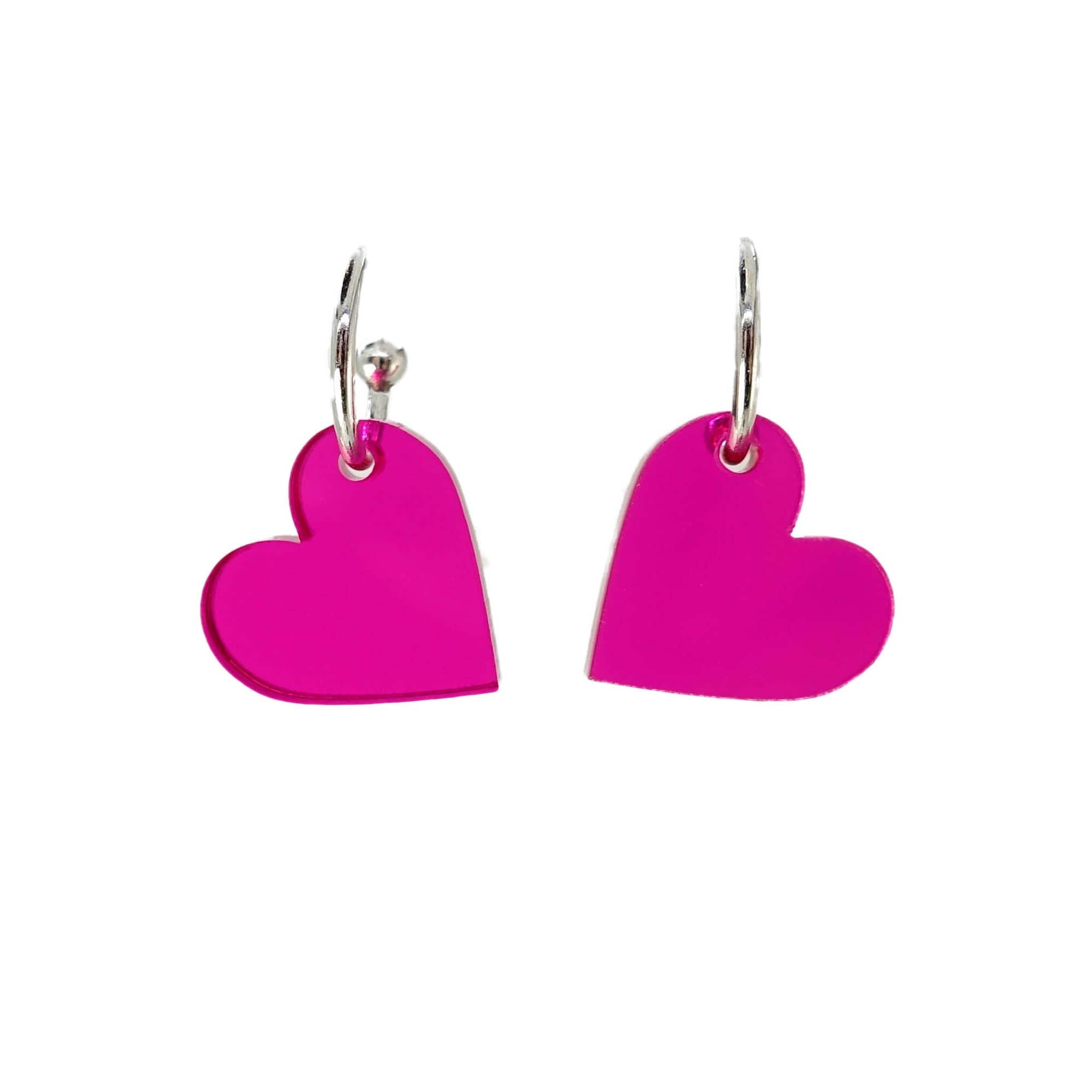 Neon pink simple heart hoop earrings on silver-plated hoops. Shown hanging against a white background.  