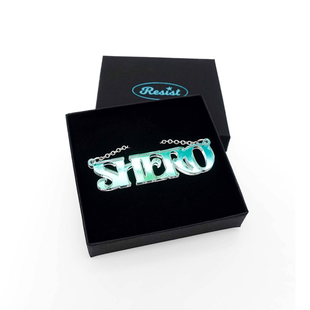 Iridescent Shero necklace shown in a Wear and Resist gift box. 