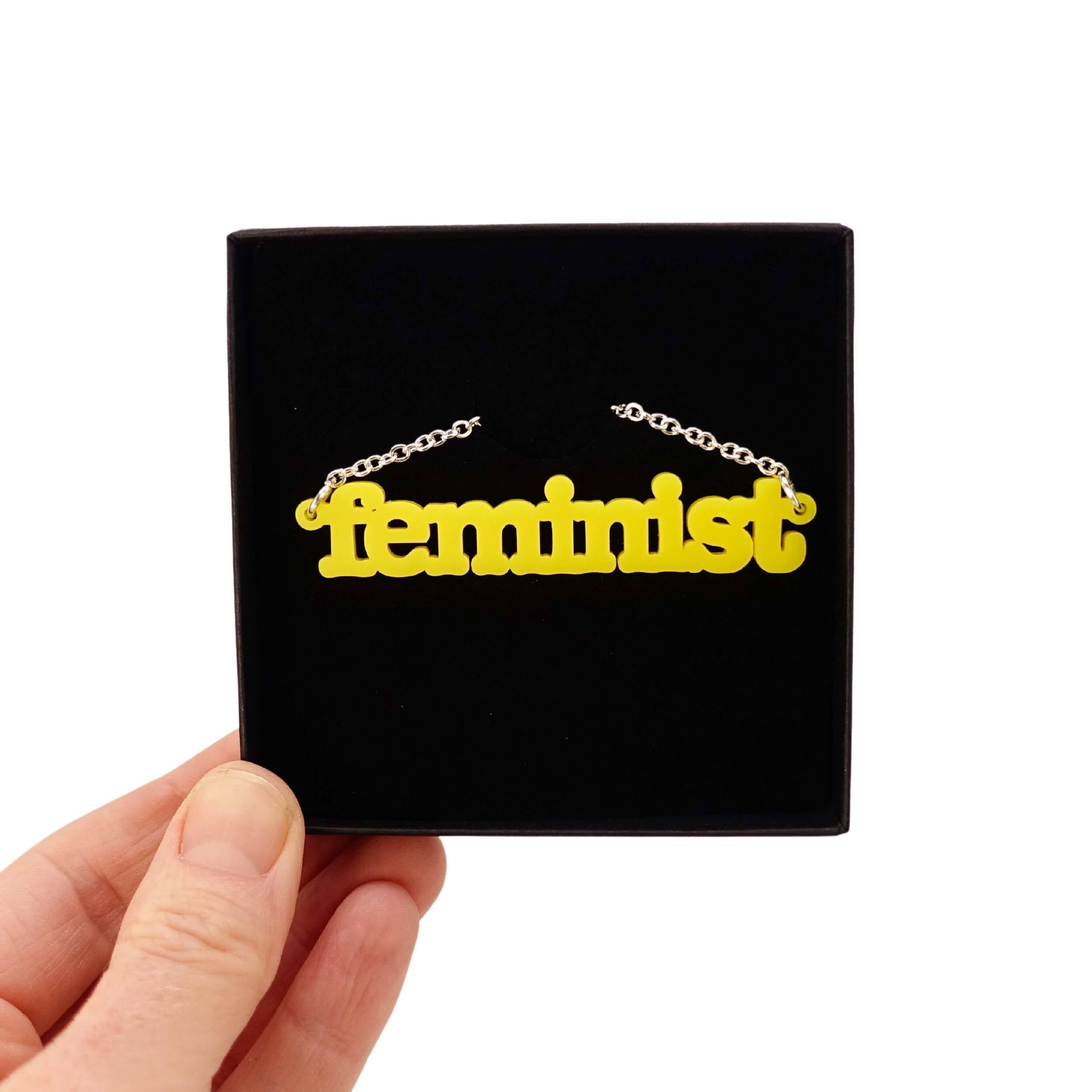 Lemon Feminist necklace shown in a Wear and Resist gift box. 
