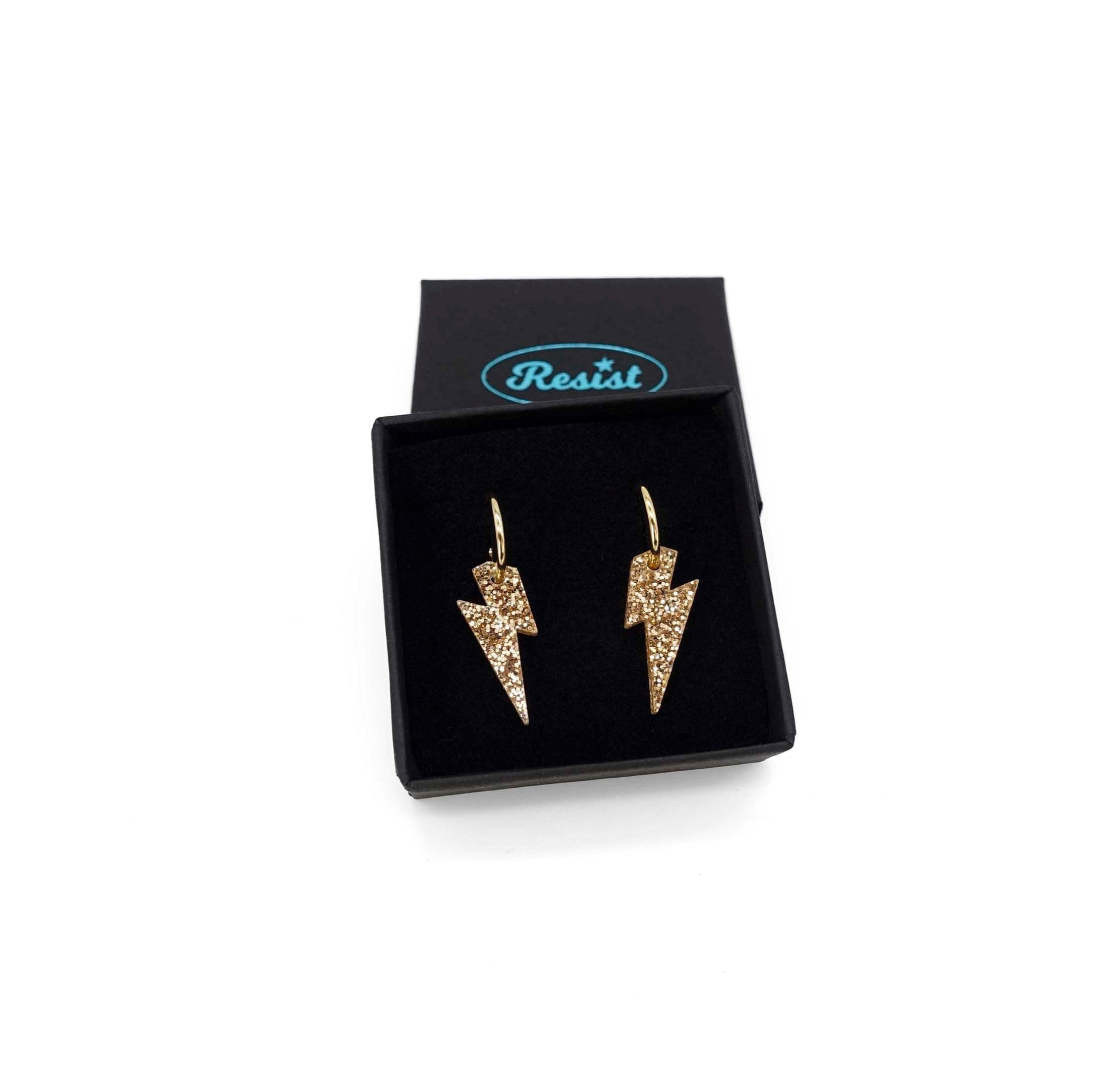 Lightning bolt hoop earrings in gold glitter on gold-plated hoops, shown in a small Wear and Resist gift box. 