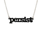 Matte black Persist necklace in typewriter font hanging on a silver chain against a white background. 