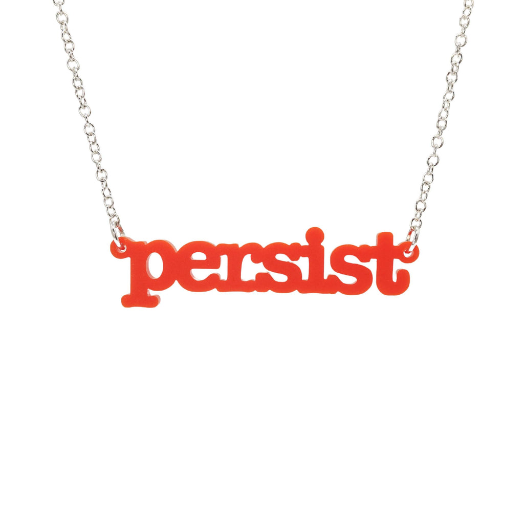 Matte red Persist necklace in typewriter font hanging on a silver chain against a white background. 