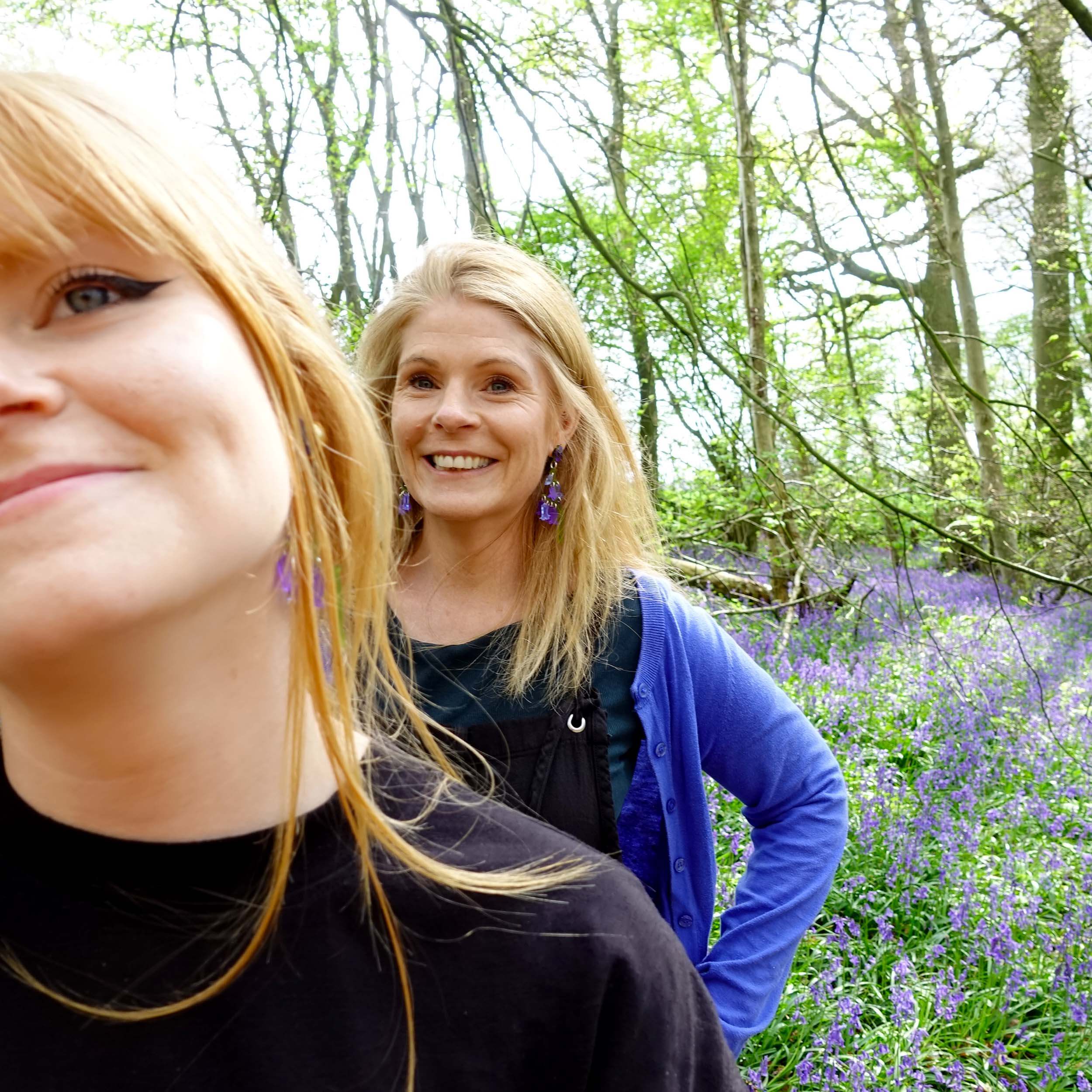 Sarah Day and her daughter Eliza Day wearing bluebell earrings in the bluebells