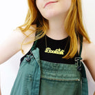 Eliza wears a lemon drop Bookish necklace designed by Sarah for Wear and Resist. £2 from everything in the Wordy Words for Writers series goes to Women for Refugee Women charity. 