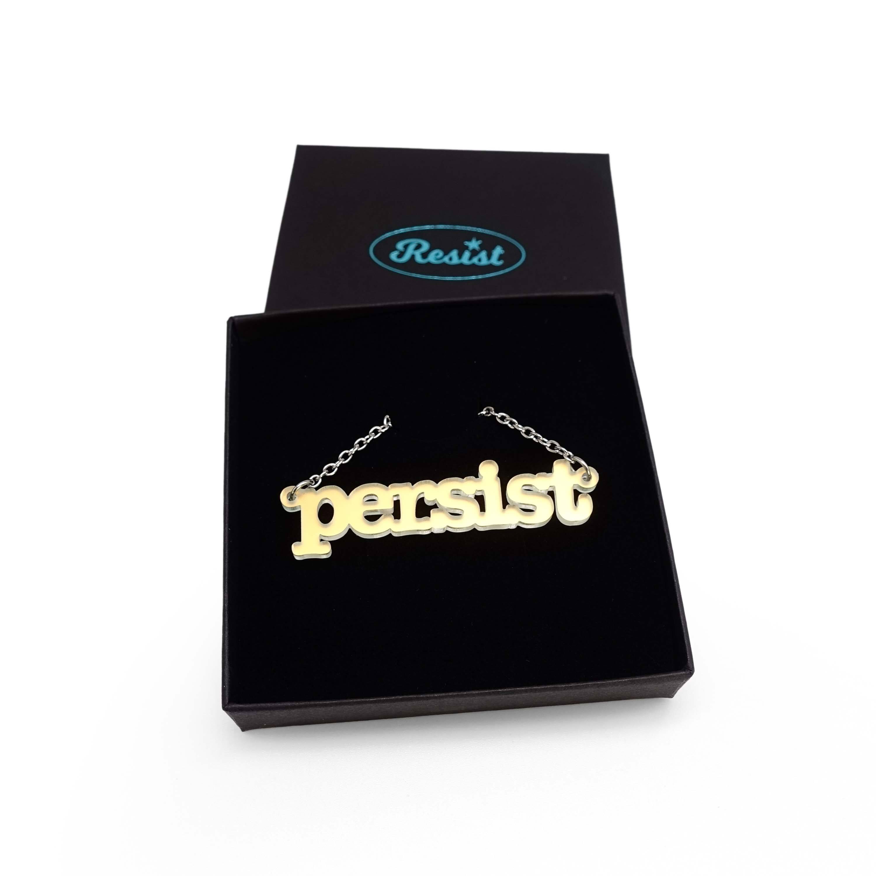 Typewriter Resist necklace in matte iridescent shown in a Wear and Resist gift box.