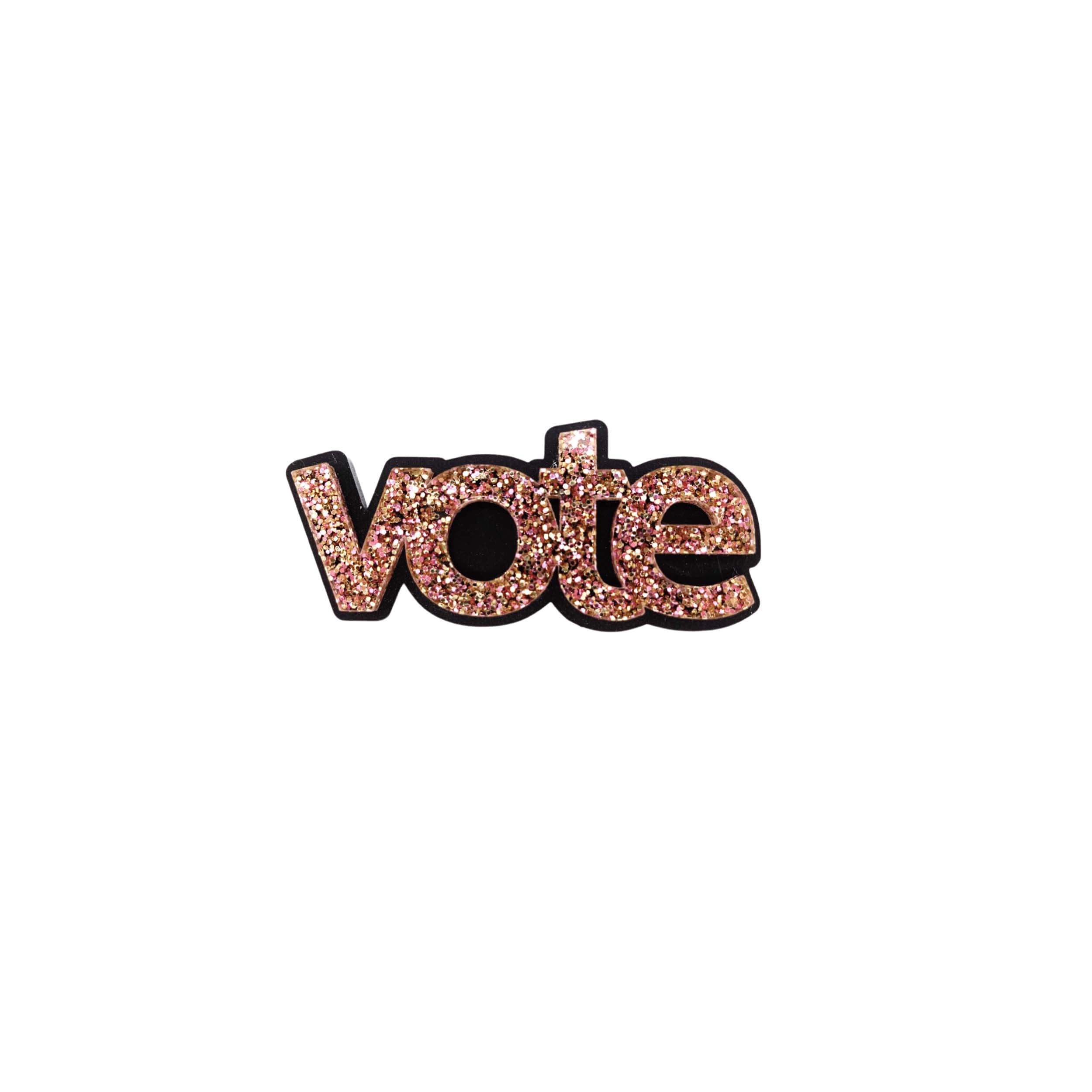 A pink fizz glitter vote brooch designed by Sarah Day for Wear and Resist. 