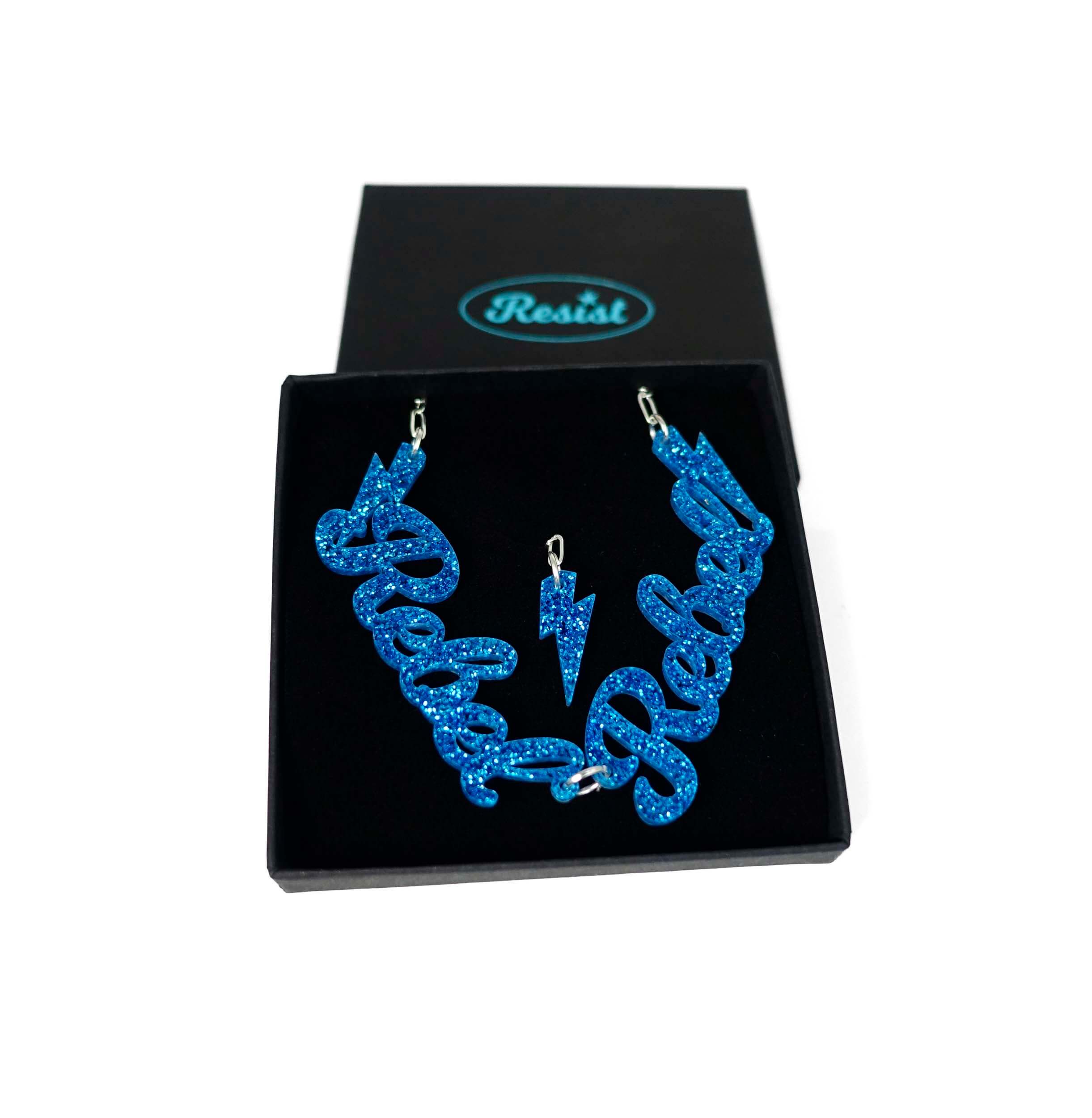 Blue glitter Rebel Rebel necklace shown in a Wear and Resist gift box. 