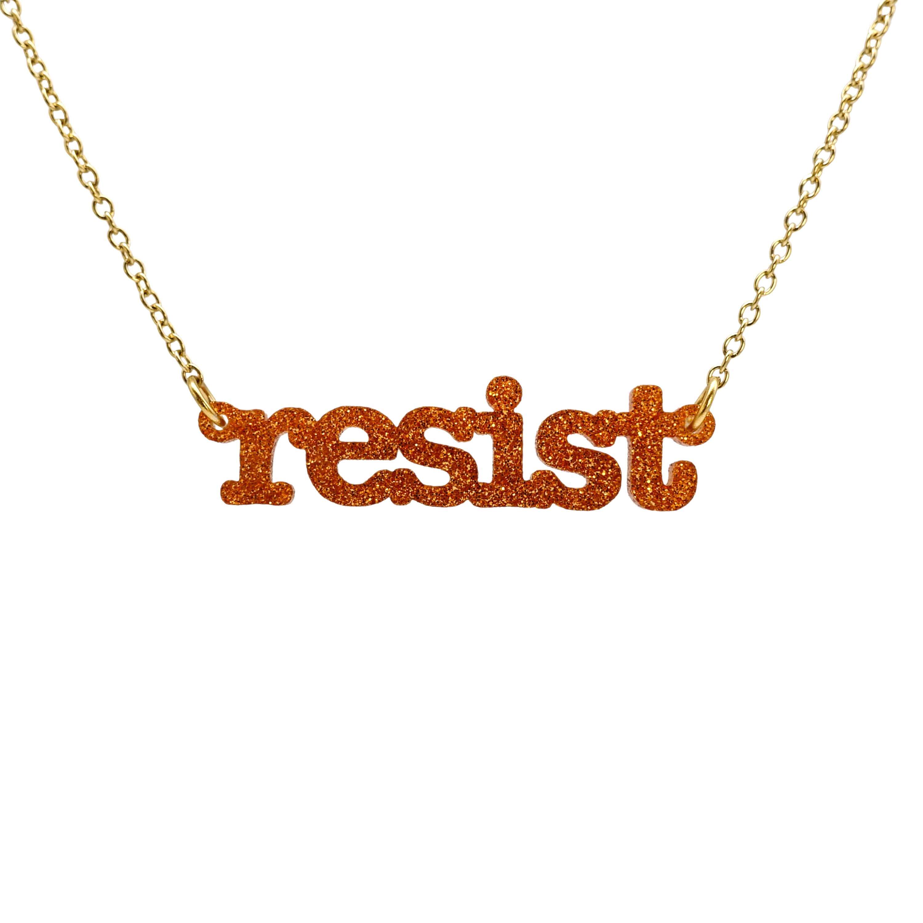 Typewriter Resist necklace in flame glitter shown hanging on a gold plated chain against a white background. 