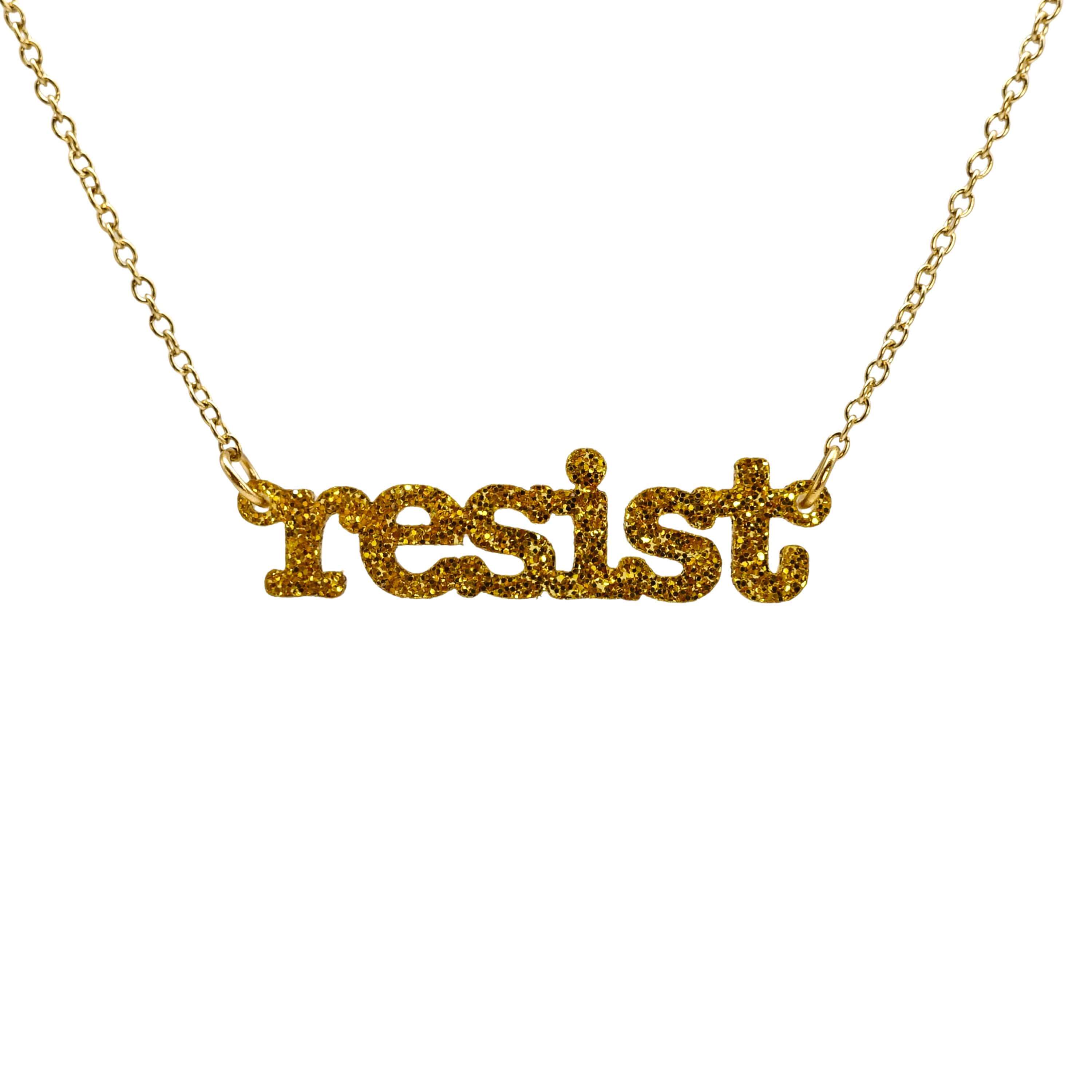 Typewriter Resist necklace in ultra gold glitter shown hanging on a gold plated chain against a white background. 
