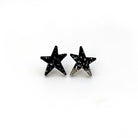Black glitter funky Wear and Resist star earrings shown on a white background. 