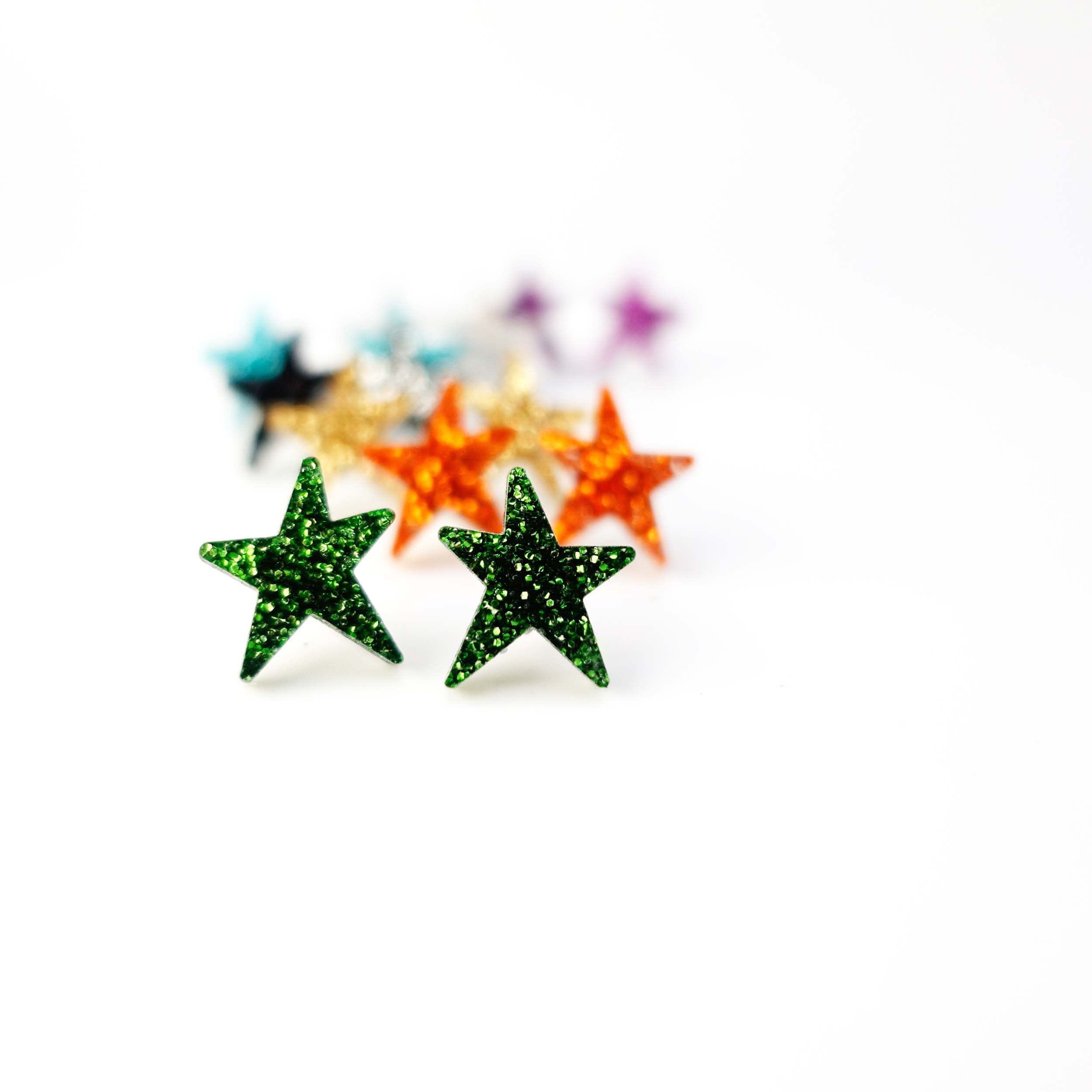 Moss glitter funky Wear and Resist star earrings shown on a white background. 