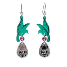 A pair of acrylic earrings with green birds holding silver 'jewels' that say 'What the F*ck'.
