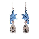 A pair of acrylic earrings with blue birds holding silver 'jewels' that say 'F*ck This' and 'Shit' 
