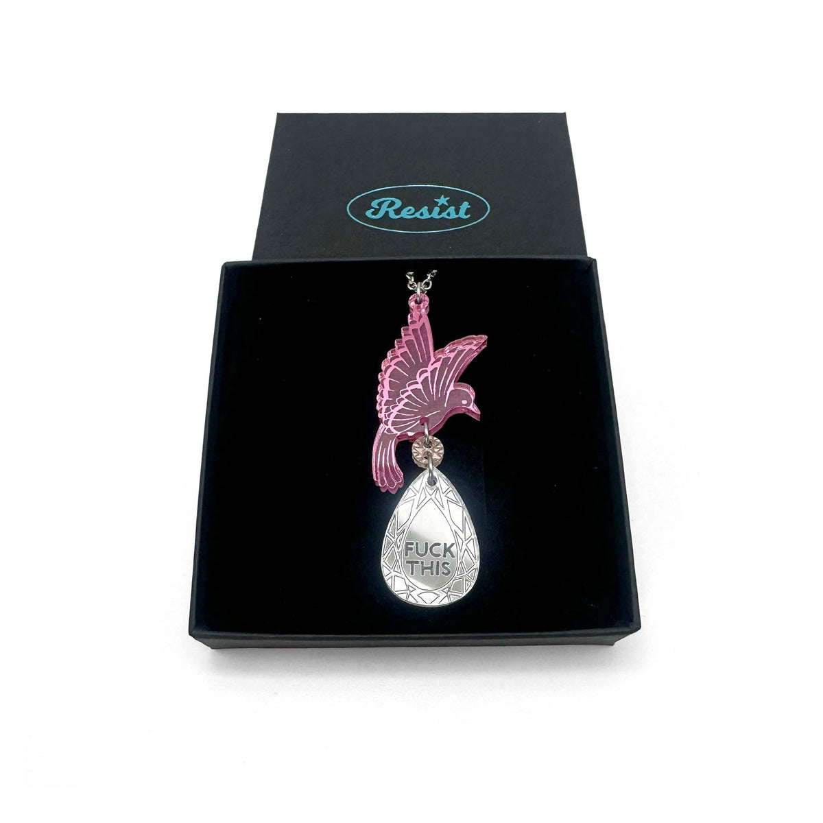 An acrylic pendant necklace with a pink bird holding a silver 'jewel' that says 'F*ck This'. Shown in a Wear & Resist gift box.