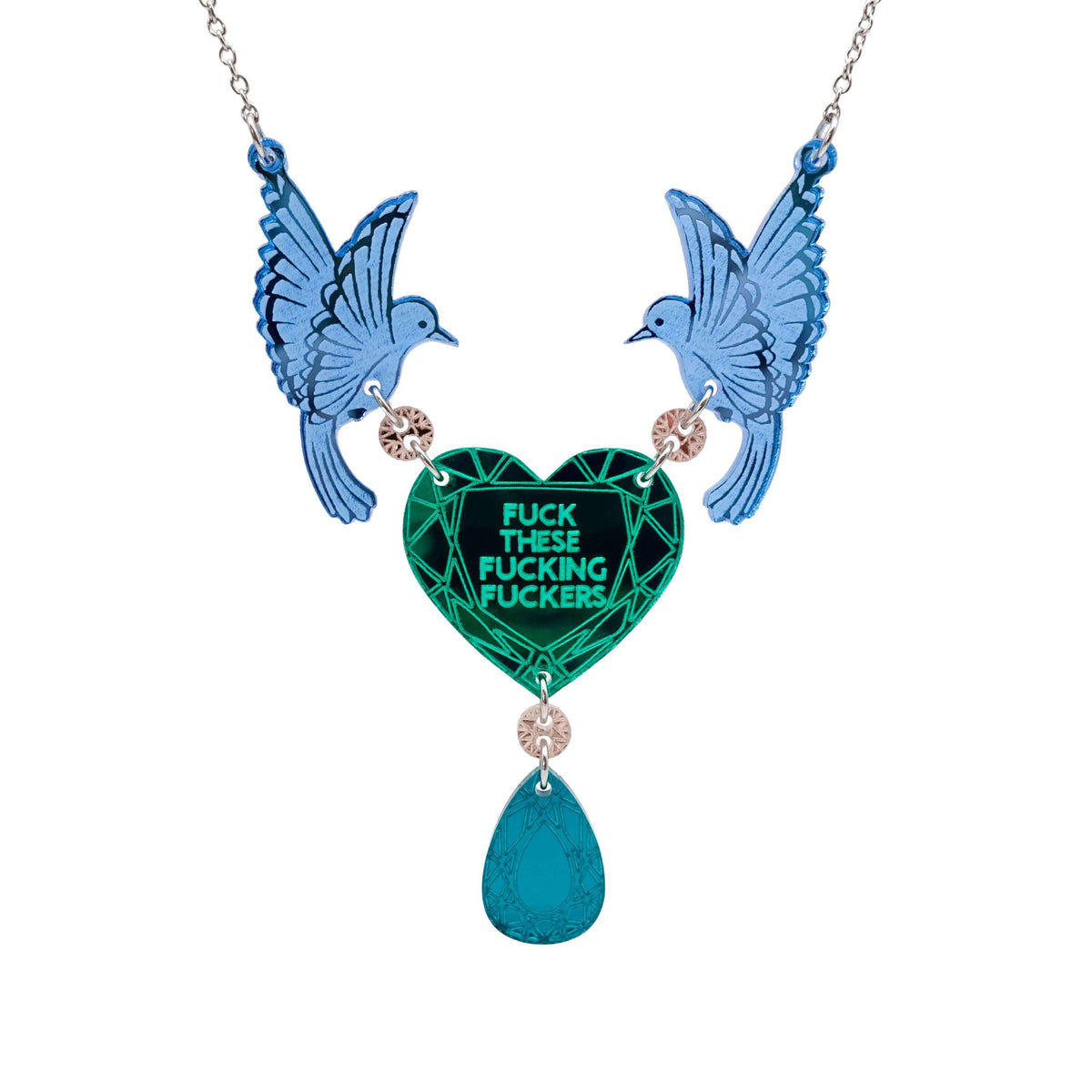 A mirror acrylic necklace with two blue birds holding a green heart that says 'Fuck these fucking fuckers' with a teal gold 'jewel' hanging from the centre. 