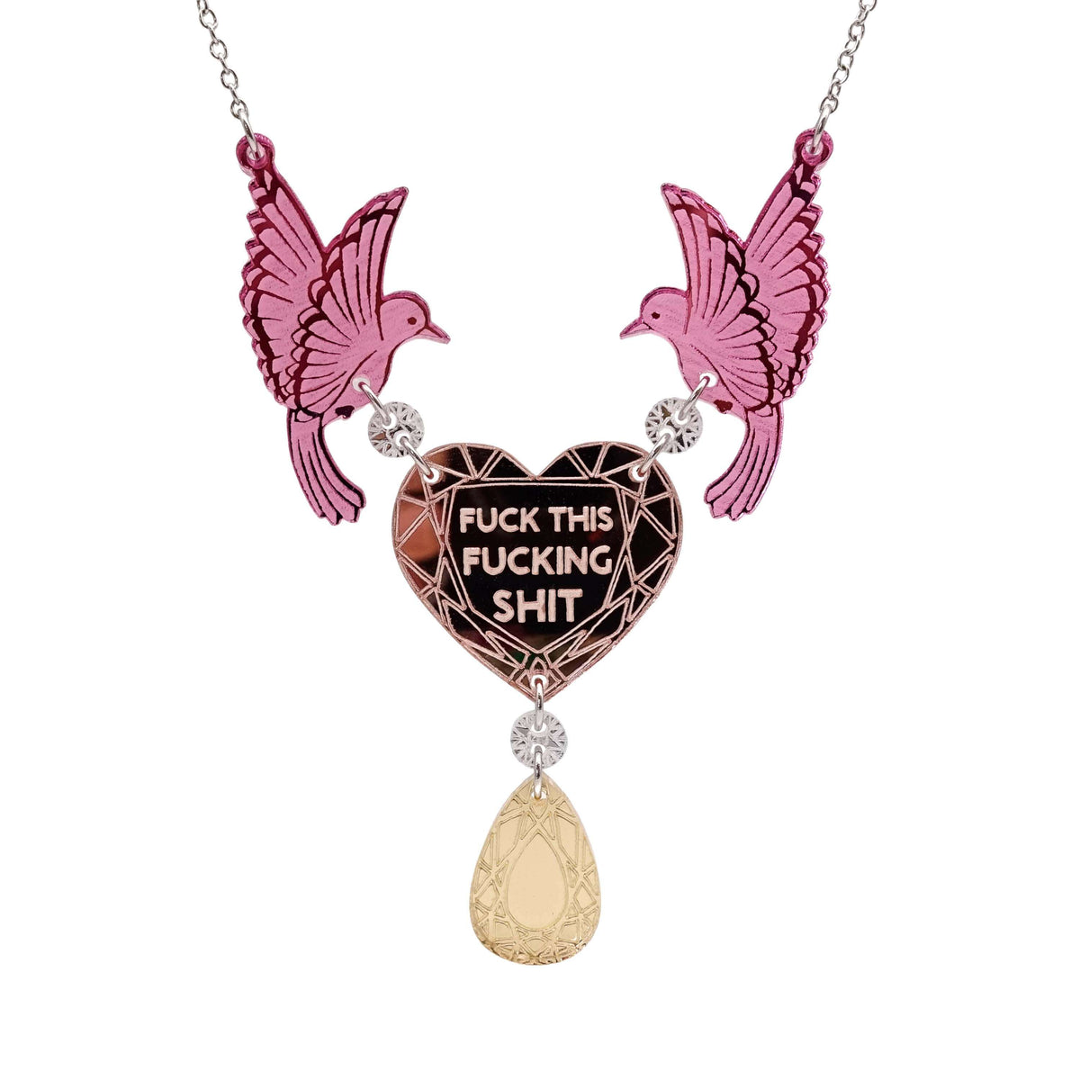 A mirror acrylic necklace with two pink birds holding a rose gold heart that says 'Fuck this fucking shit' with a gold 'jewel' hanging from the centre. 