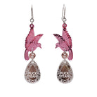 A pair of acrylic earrings with pink birds holding silver 'jewels' that say 'F*ck Yeah'.