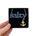 Salty necklace with keep clear anchor shown held up in a Wear and Resist gift box. 
