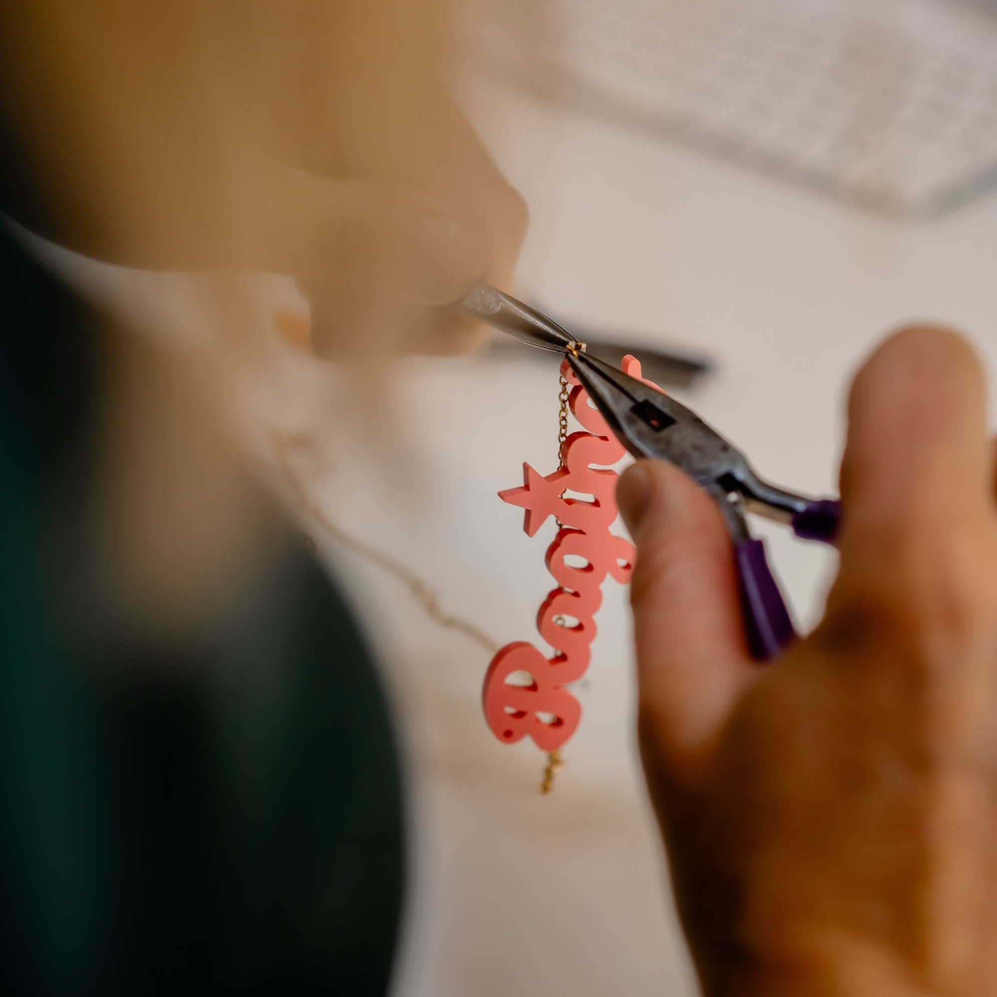Sarah puts a chain on a Raging necklace.