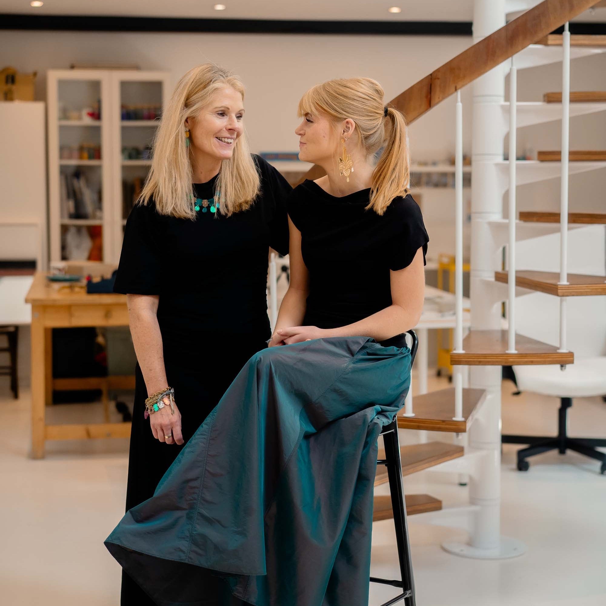 Sarah wearing the Belle Epoque necklace in teal and Eliza wearing Festive drop earrings sitting in the Wear and Resist studio. 