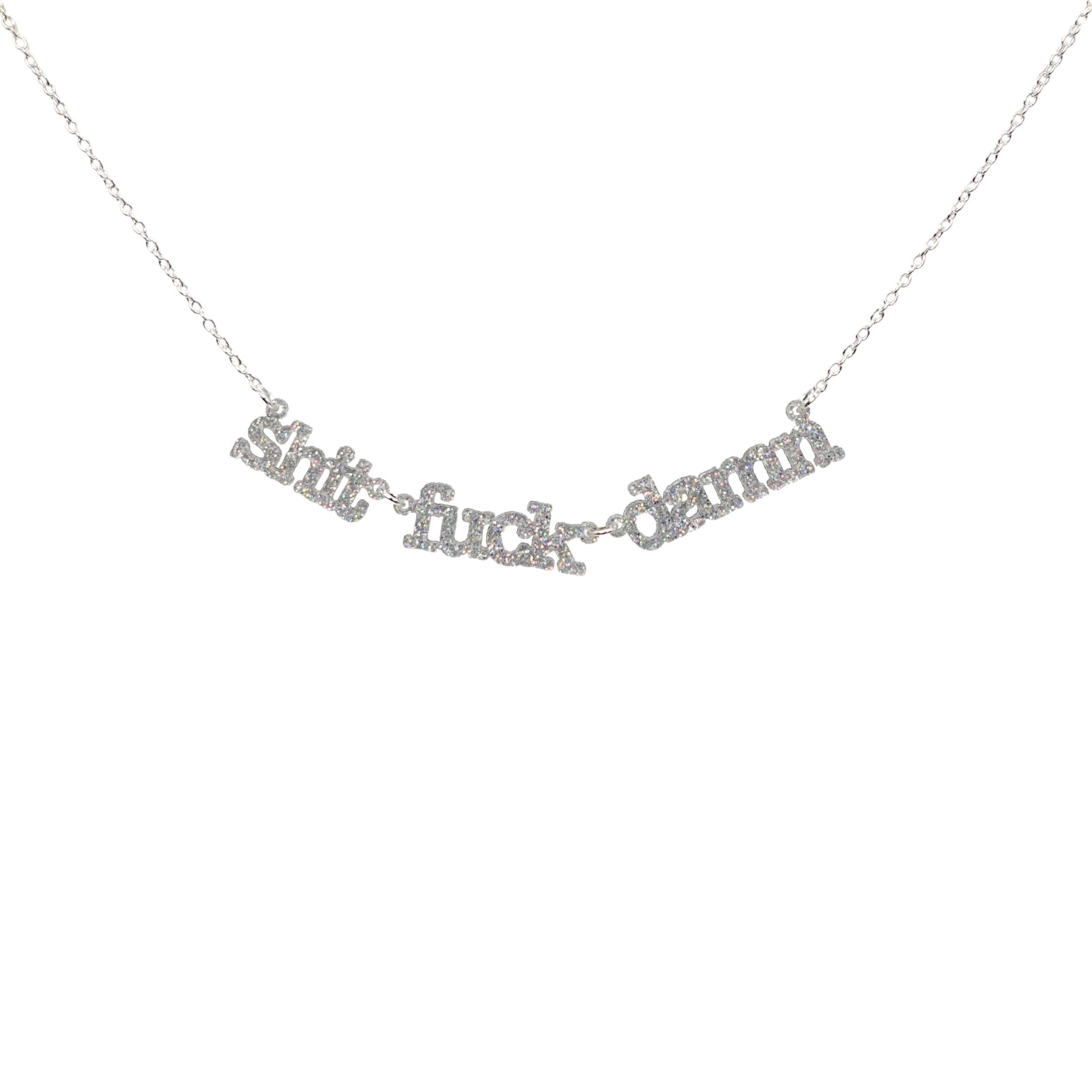 Sh*t f*ck d*mn necklace in silver glitter shown hanging against a white background. Swearing is caring! 