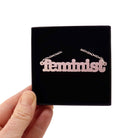 Shell pink Feminist necklace shown in a Wear and Resist gift box. 