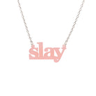 Slay necklace in blush pink on a silver chain shown hanging against a white background. Designed by Sarah Day for Wear and Resist. £2 goes to Women for Refugee Women charity. 
