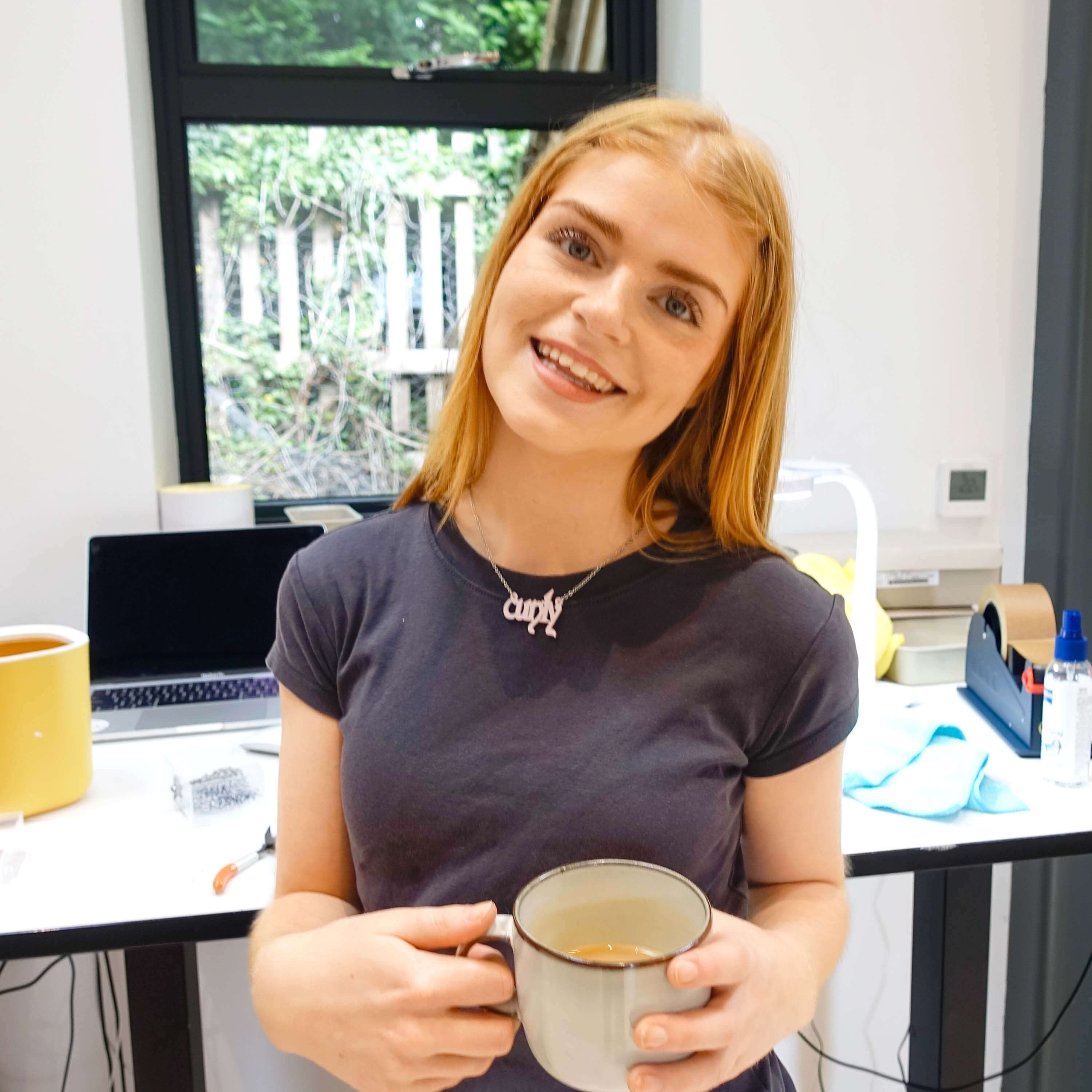 Eliza smiles wearing a Cunty necklace in the studio. 