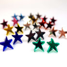 A group shot of all the funky Resist star earrings shown standing on a white surface. 