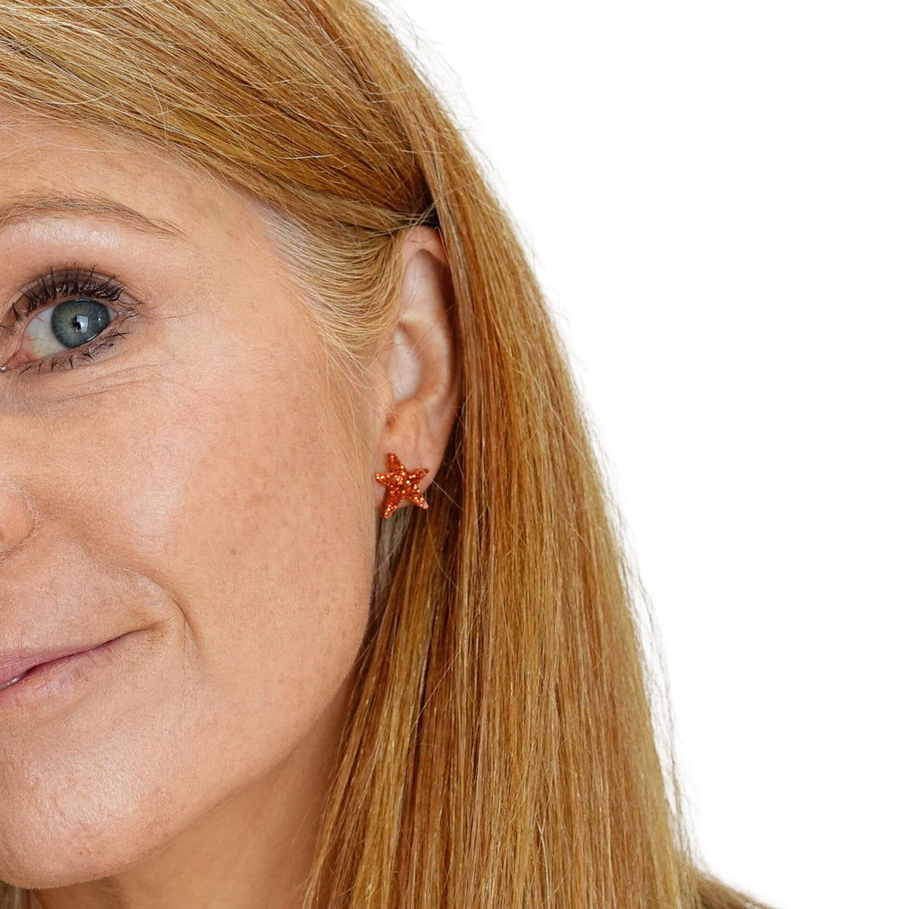 Sarah Day wears flame glitter funky Wear and Resist star earrings.