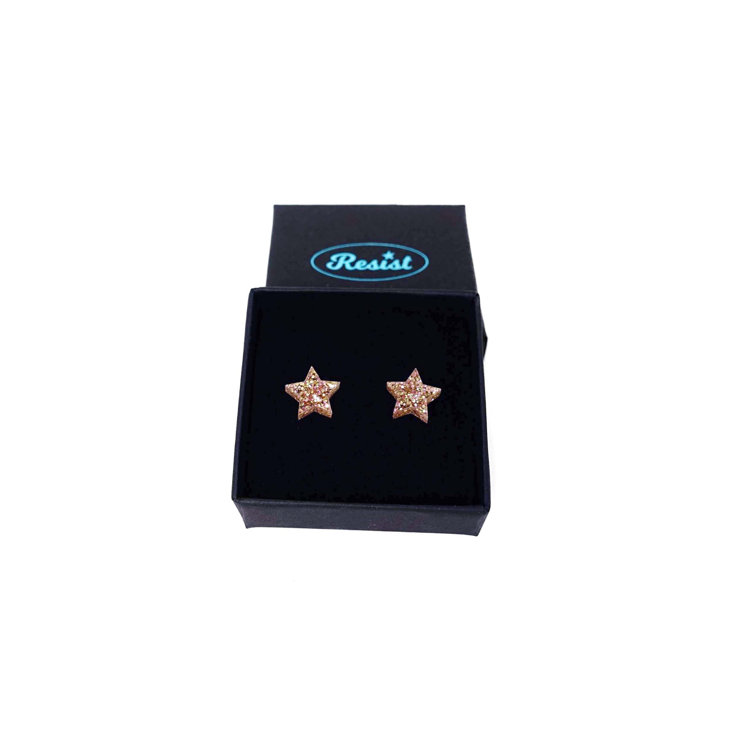 Small star earrings in pink fizz glitter shown in a Wear and Resist gift box. 