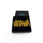 Difficult Woman necklace in ultra gold glitter, shown in a Wear and Resist gift box.