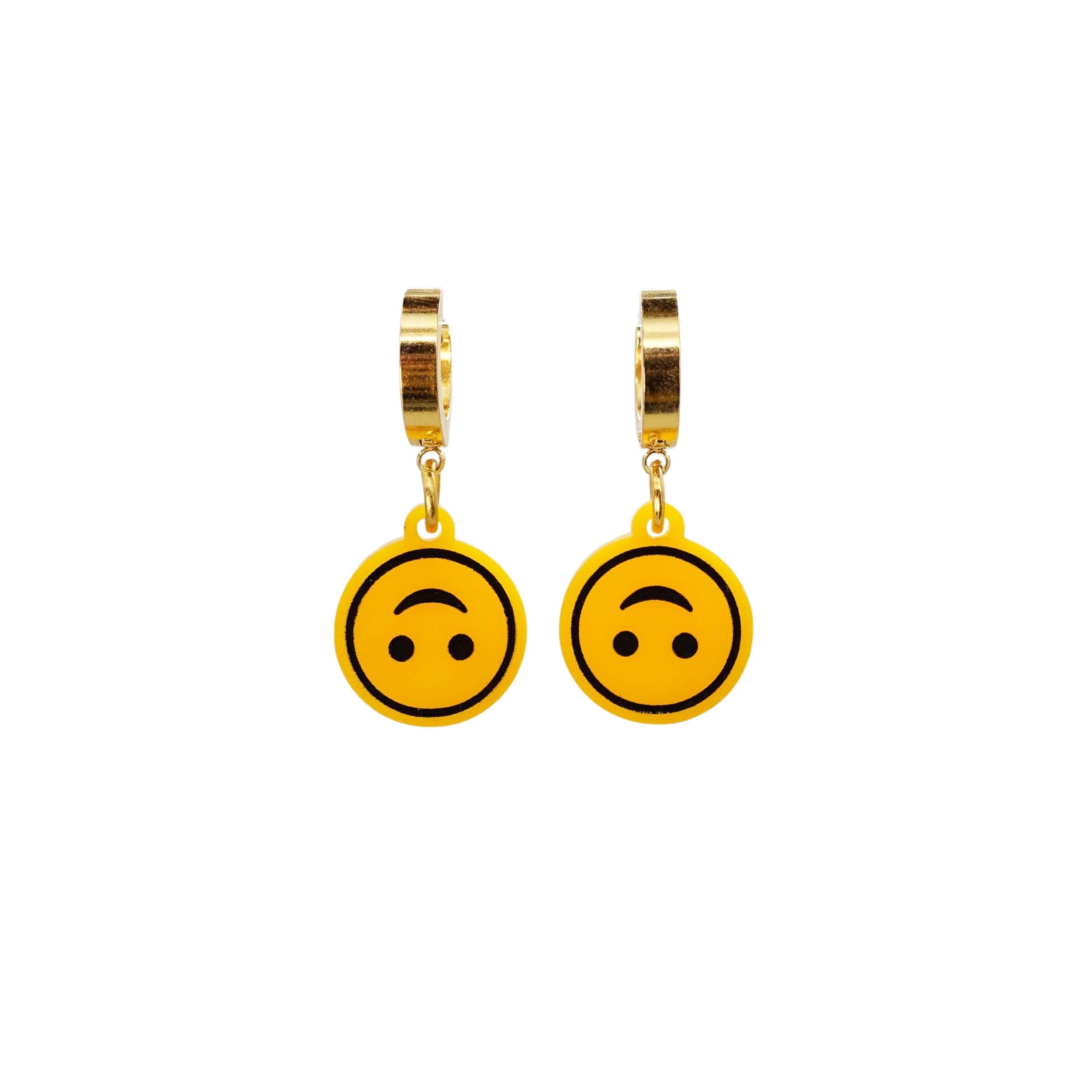 Upside-down smiley face earrings on gold huggie hoops, shown hanging against a white background. 