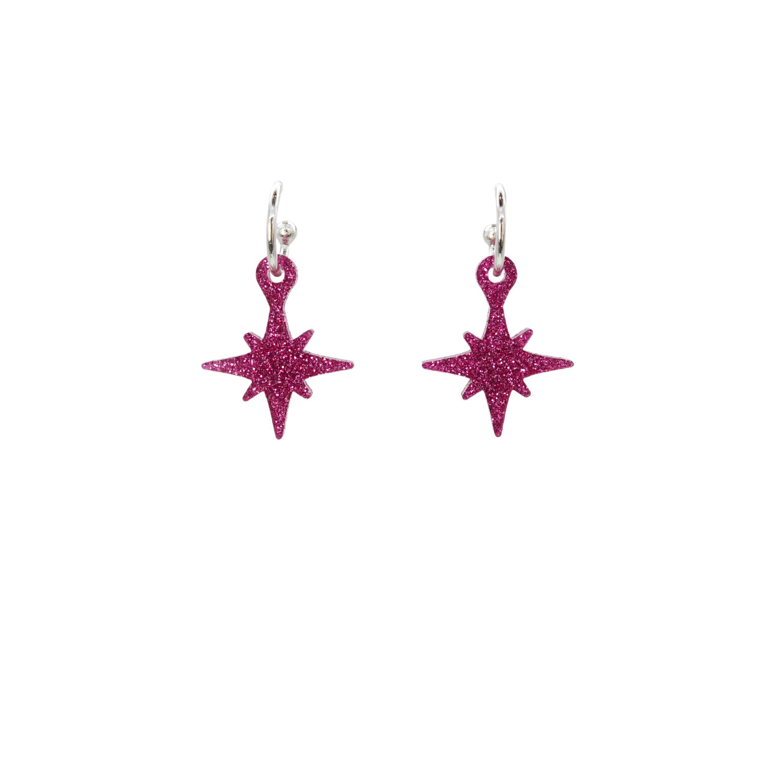 hot pink glitter vintage star earrings on hoops shown hanging on a white backround. 