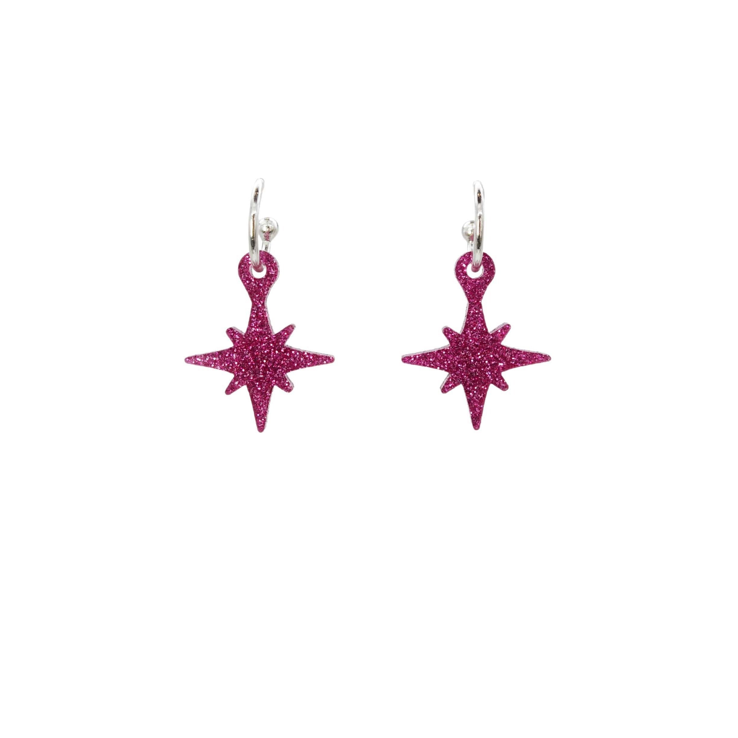 Hot pink glitter vintage star earrings on hoops shown hanging on a white backround. 