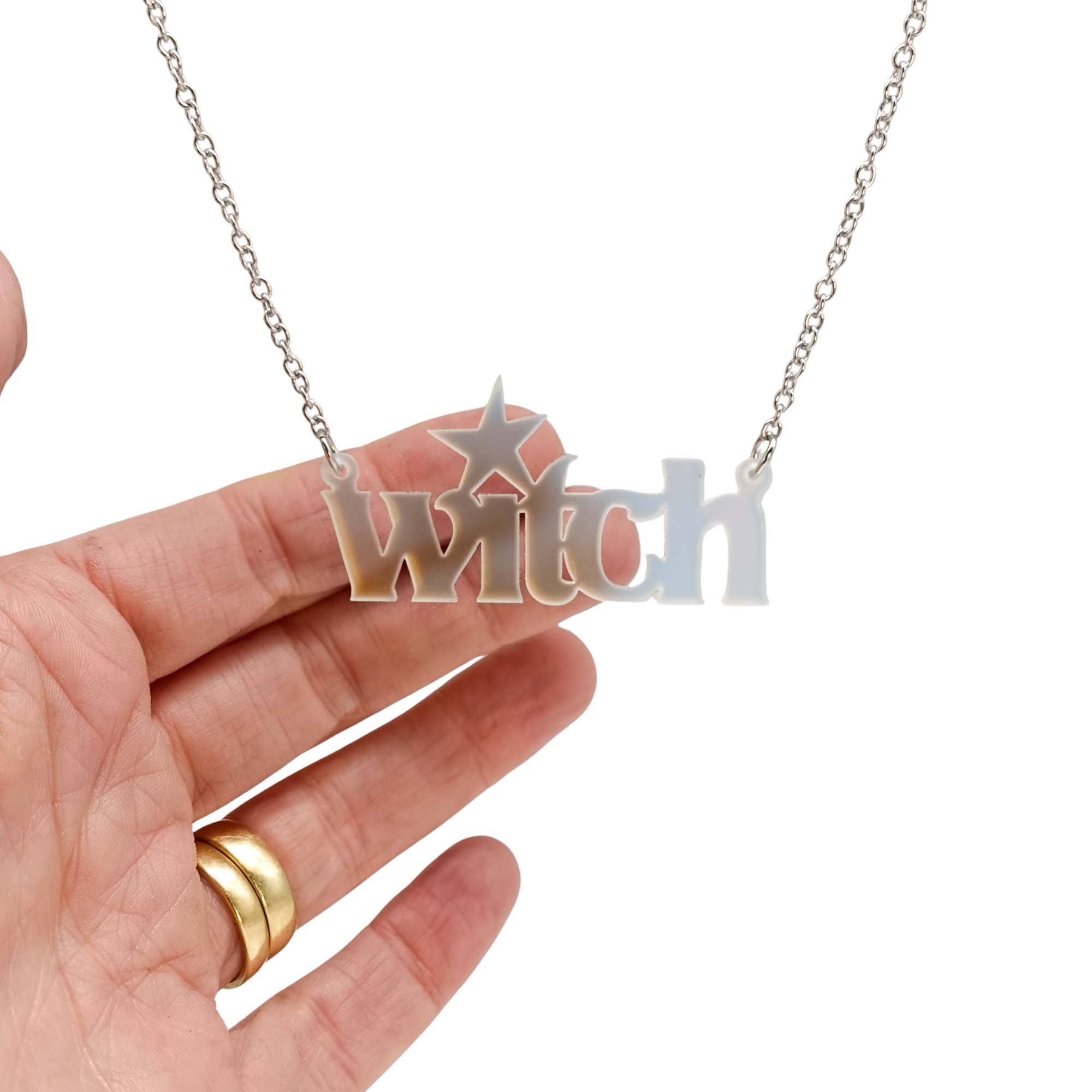 Witch necklace in matte iridescent with my hand behind for scale and to show the quality of the iridescent material. 
