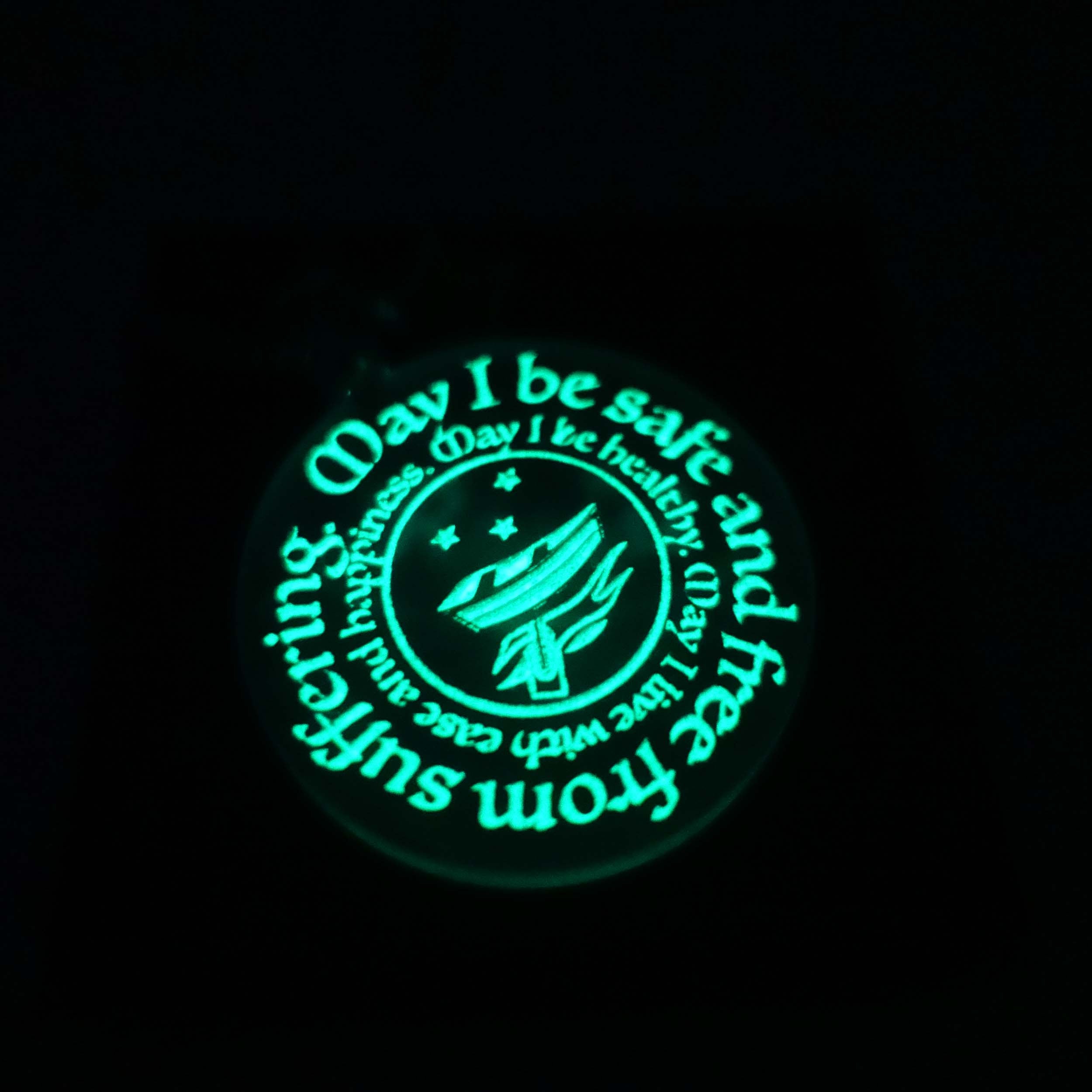 RNLI safe pendant shown glowing in the dark. 