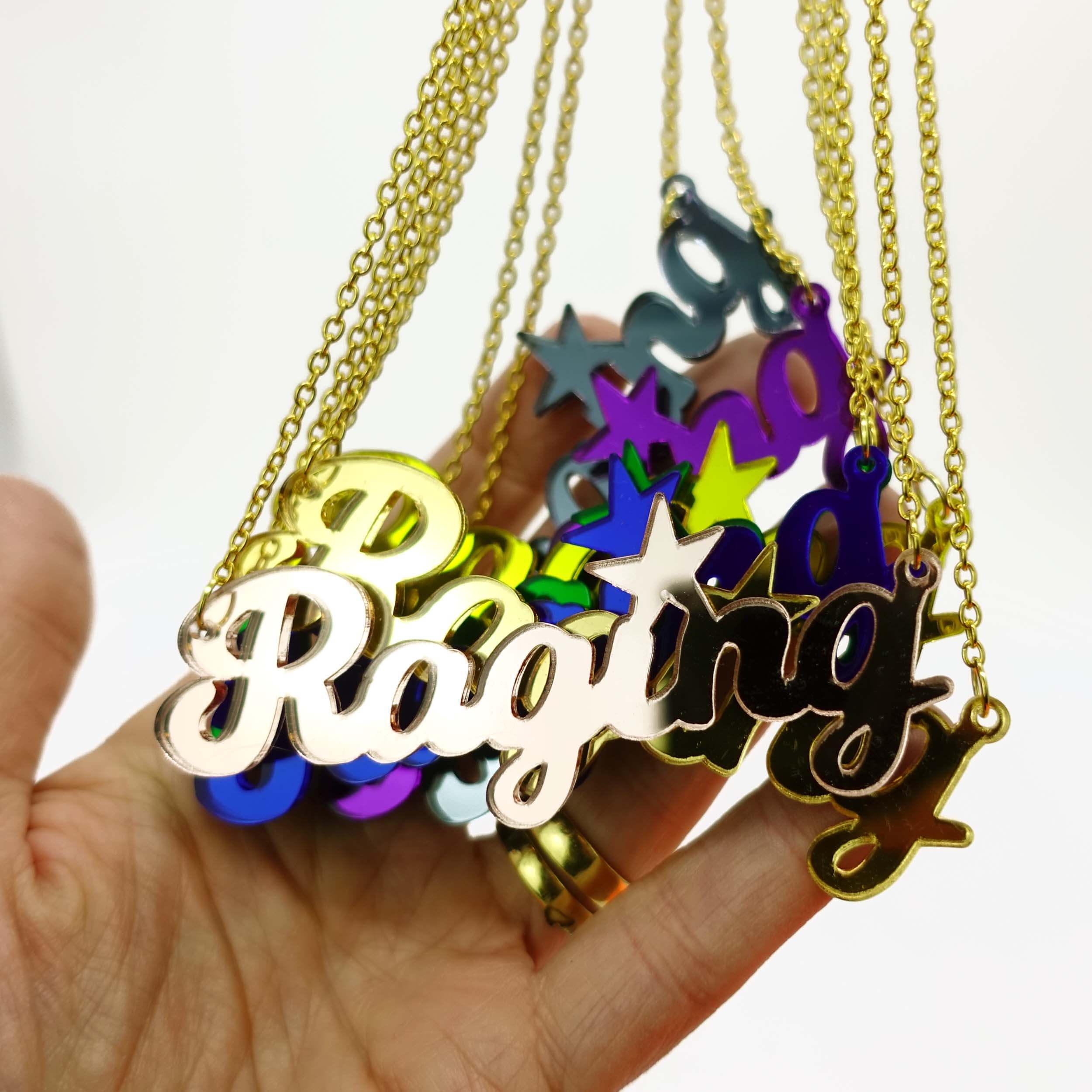 Group shot of new mirror Raging necklaces shown hanging with a hand behind for size, designed by Sarah Day the founder of Wear and Resist, raising money for women's charities. 