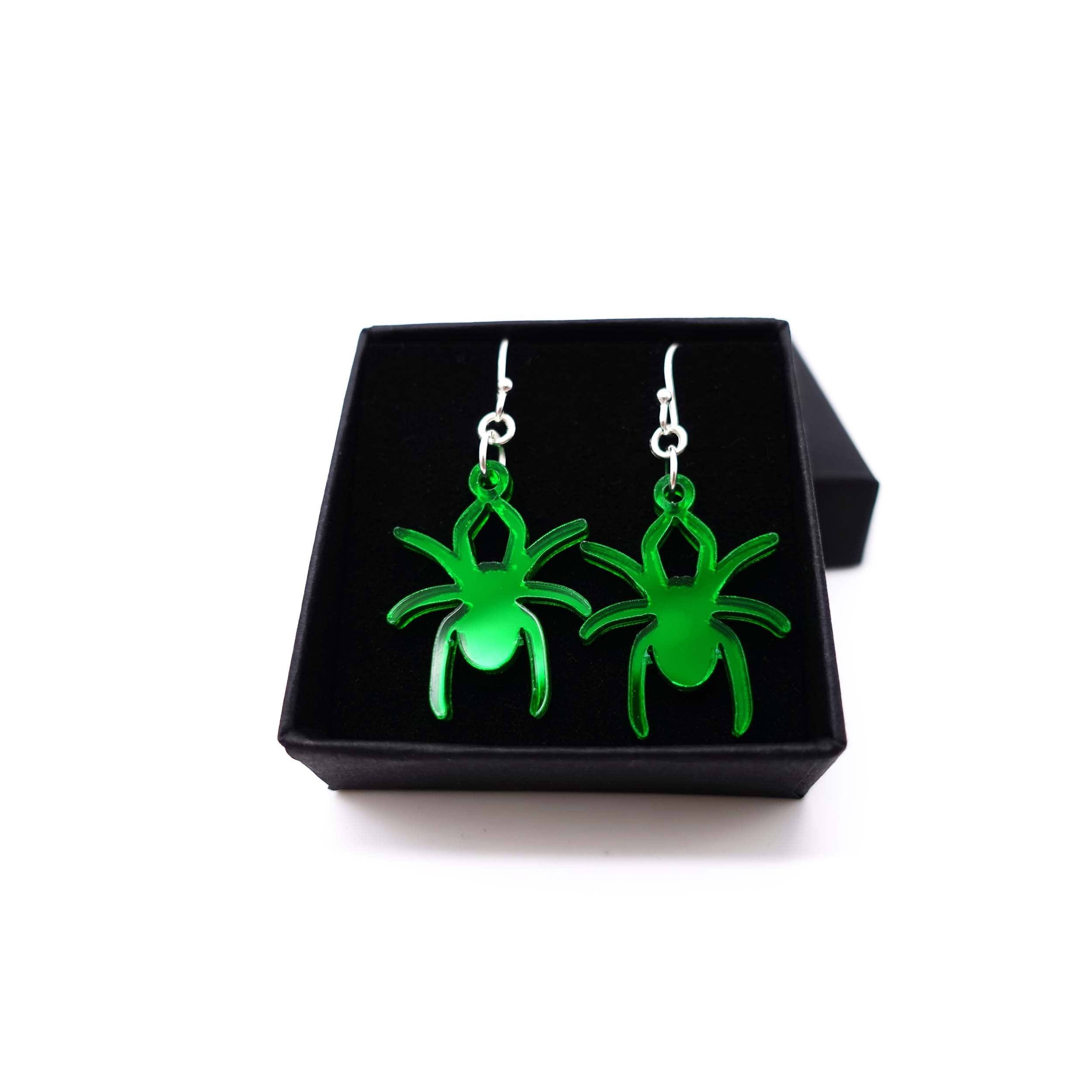 Lady Hale commemorative spider earrings in envy green mirror shown in box.