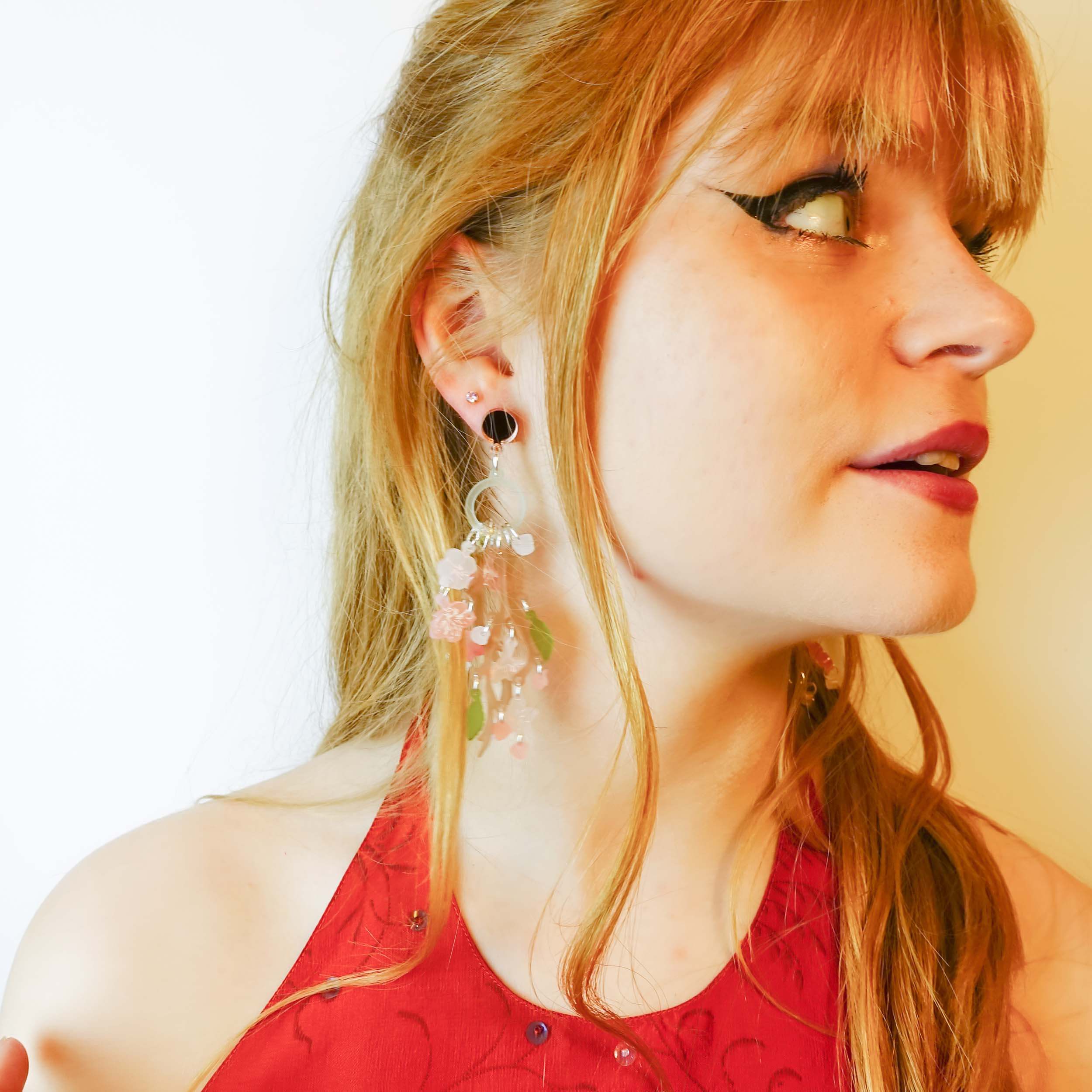 Model wears Cherry Blossom limited edition statement earrings by Wear and Resist. 