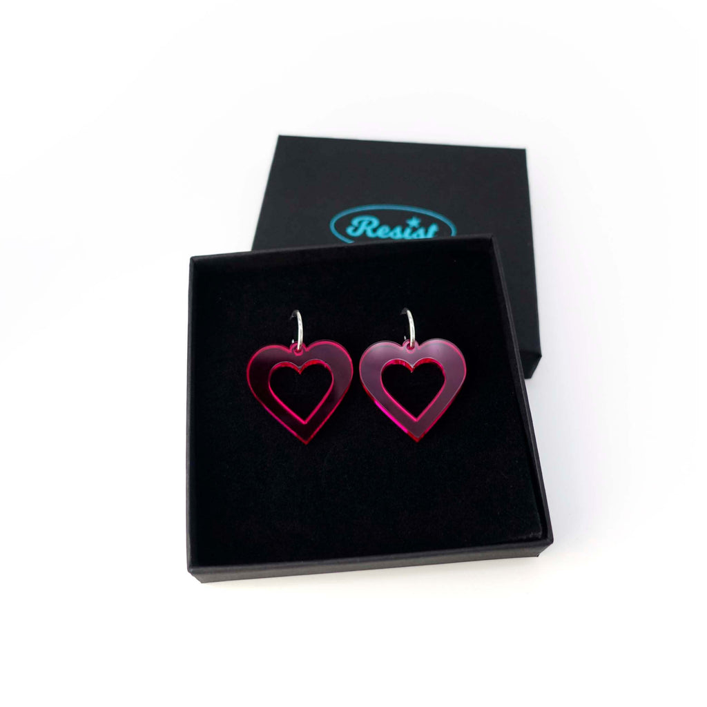 Big transparent hot pink love heart hoop earrings shown in a Wear and Resist gift box. 