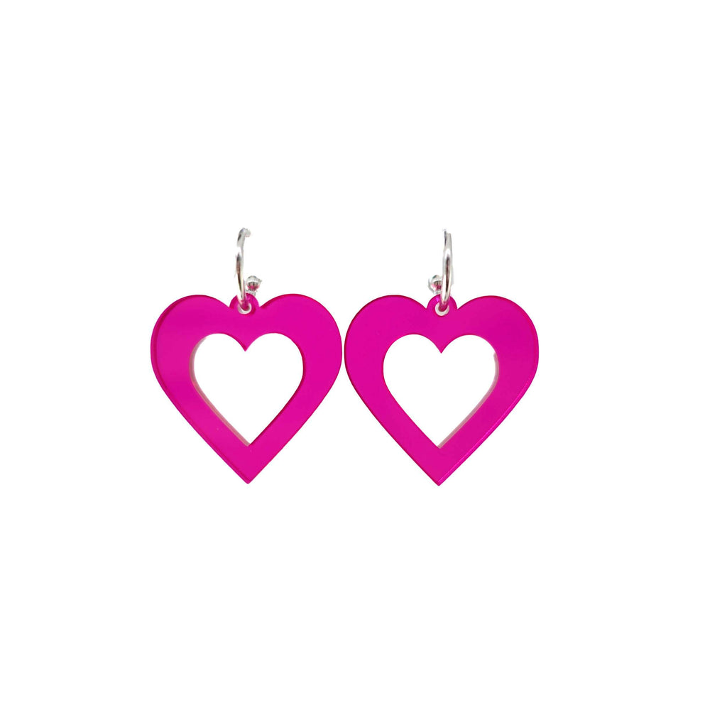 Big hot fluorescent pink love heart hoop earrings shown hanging on a white background. 