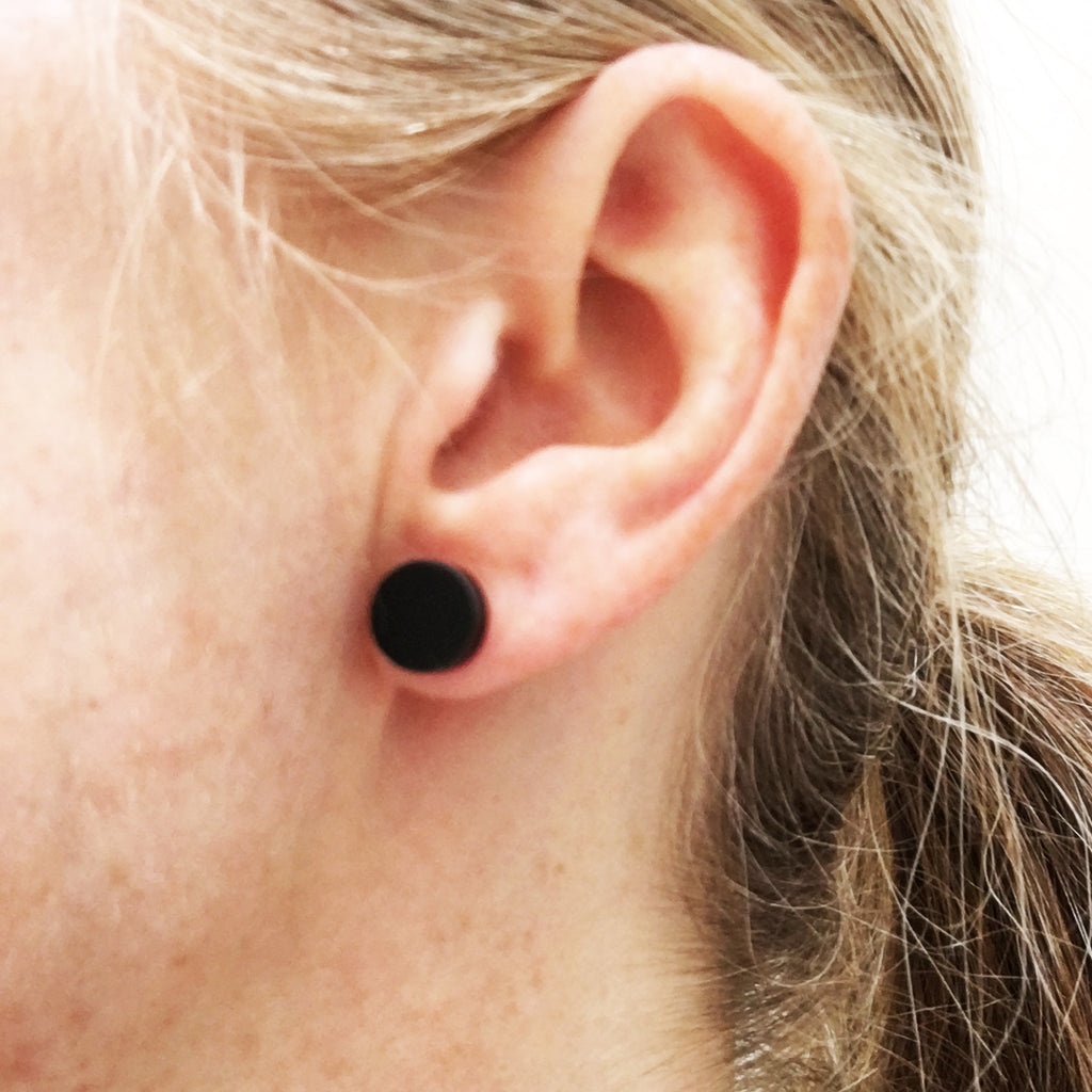 model wears matte black dot earrings